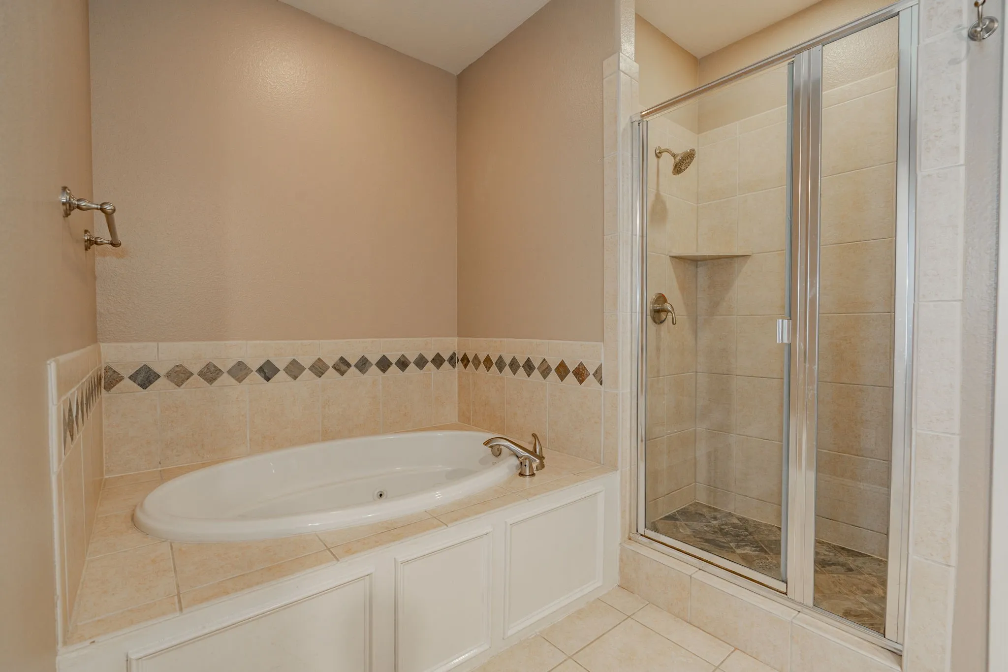 Full bath with a stall shower, a bath, and tile patterned flooring