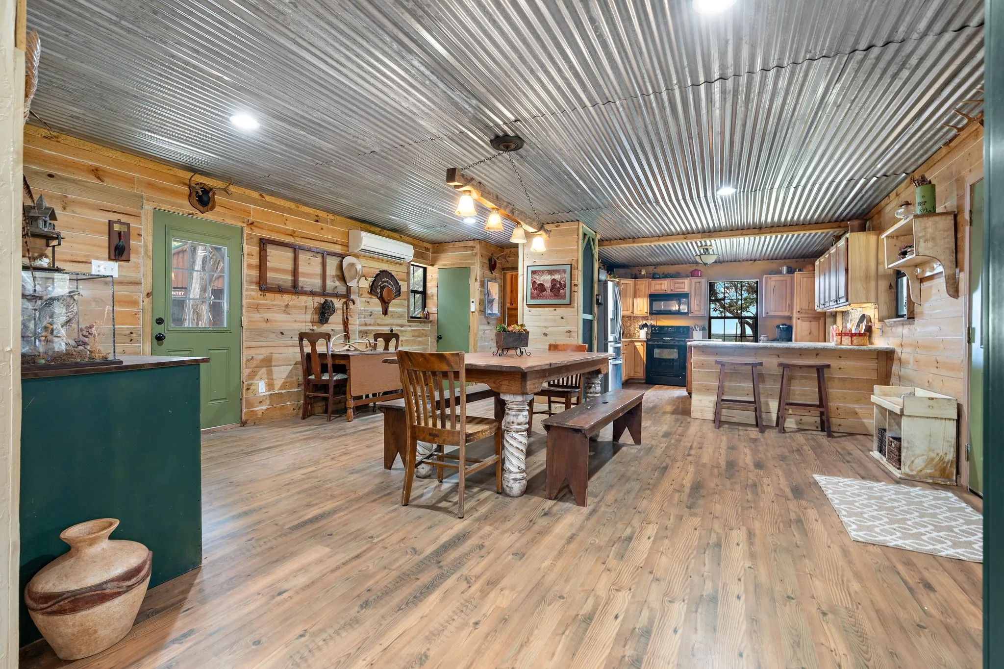 Dining room with a wall unit AC, light wood-type flooring, wood walls, and recessed lighting