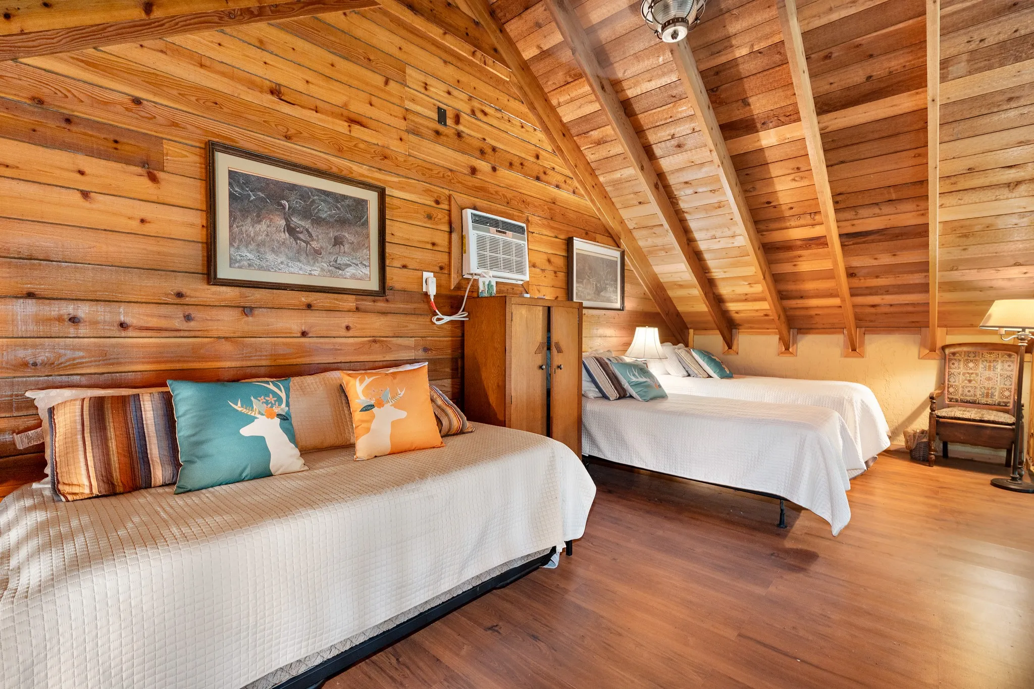 Bedroom with wood ceiling, wood finished floors, a wall mounted AC, and wooden walls