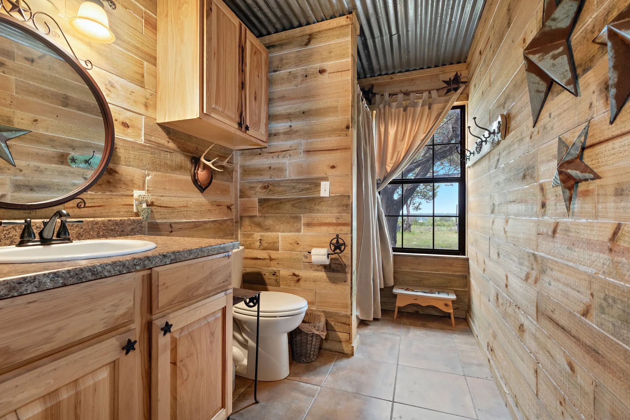 Bathroom featuring wood walls, toilet, vanity, and tile patterned flooring