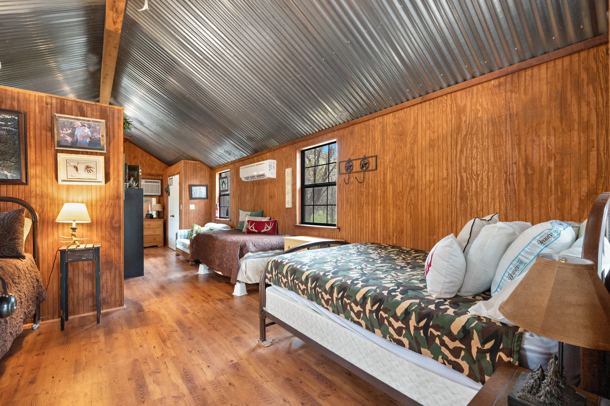 Bedroom featuring lofted ceiling, wood finished floors, wood walls, and a wall unit AC