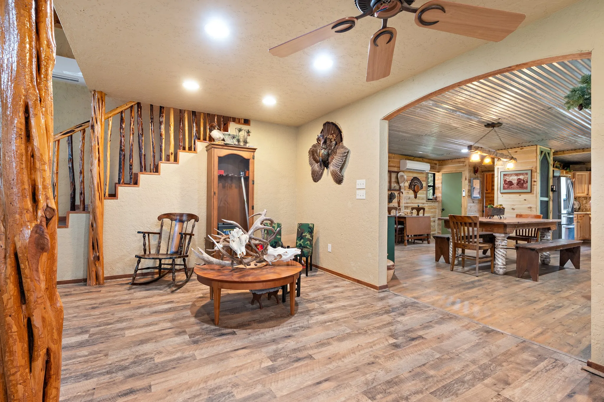 Living area featuring wood finished floors, ceiling fan, recessed lighting, baseboards, and an AC wall unit