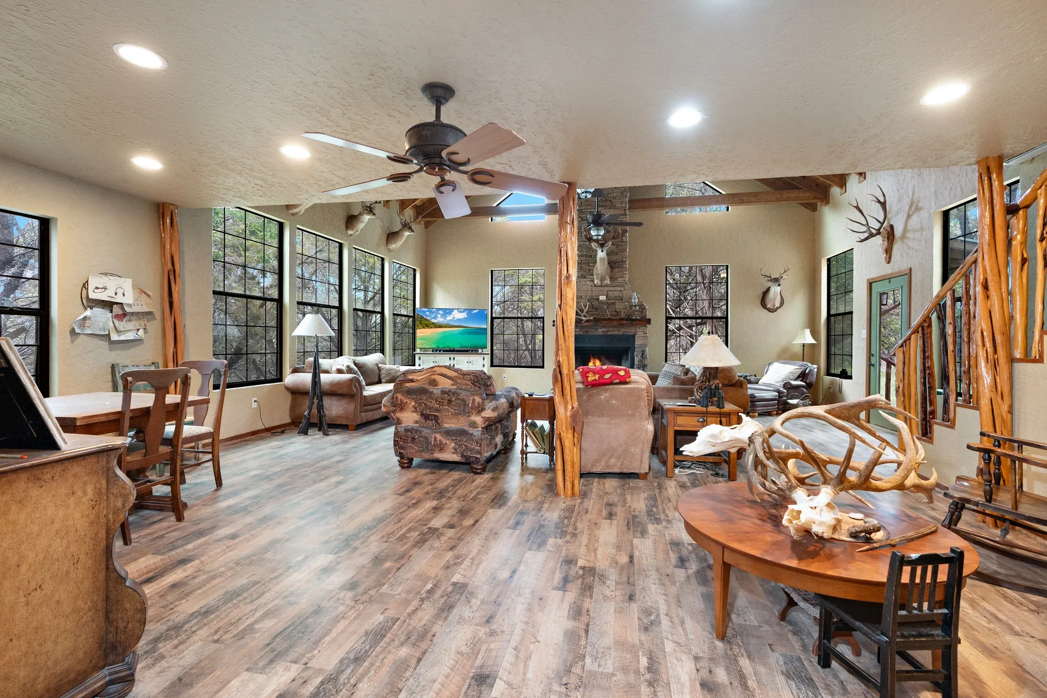 Living room with a ceiling fan, wood finished floors, recessed lighting, a fireplace, and stairs