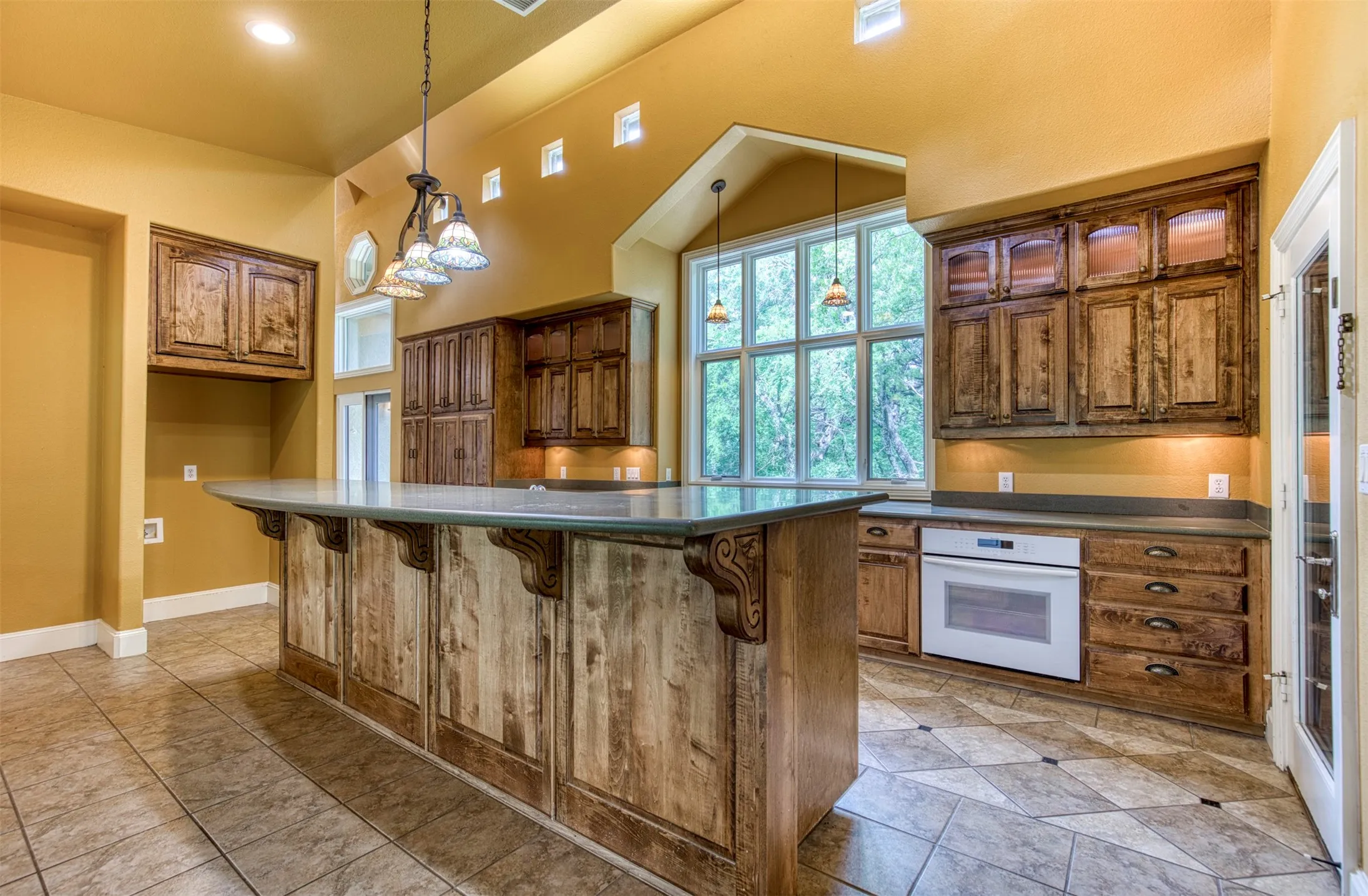 Kitchen with warm wood cabinetry and under-cabinet lighting.