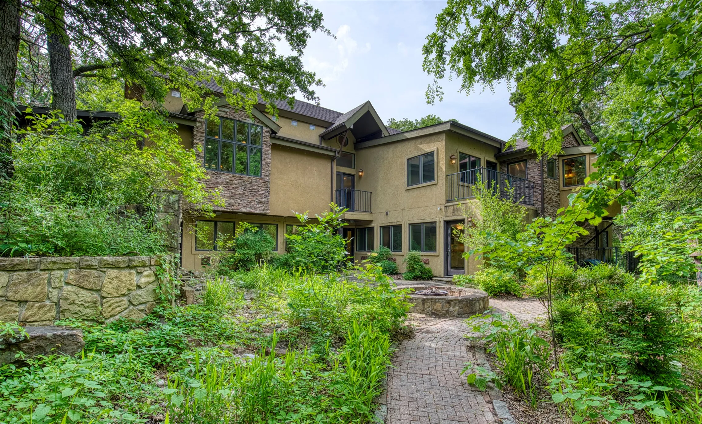 Back of home showcasing landscaping and pathways.