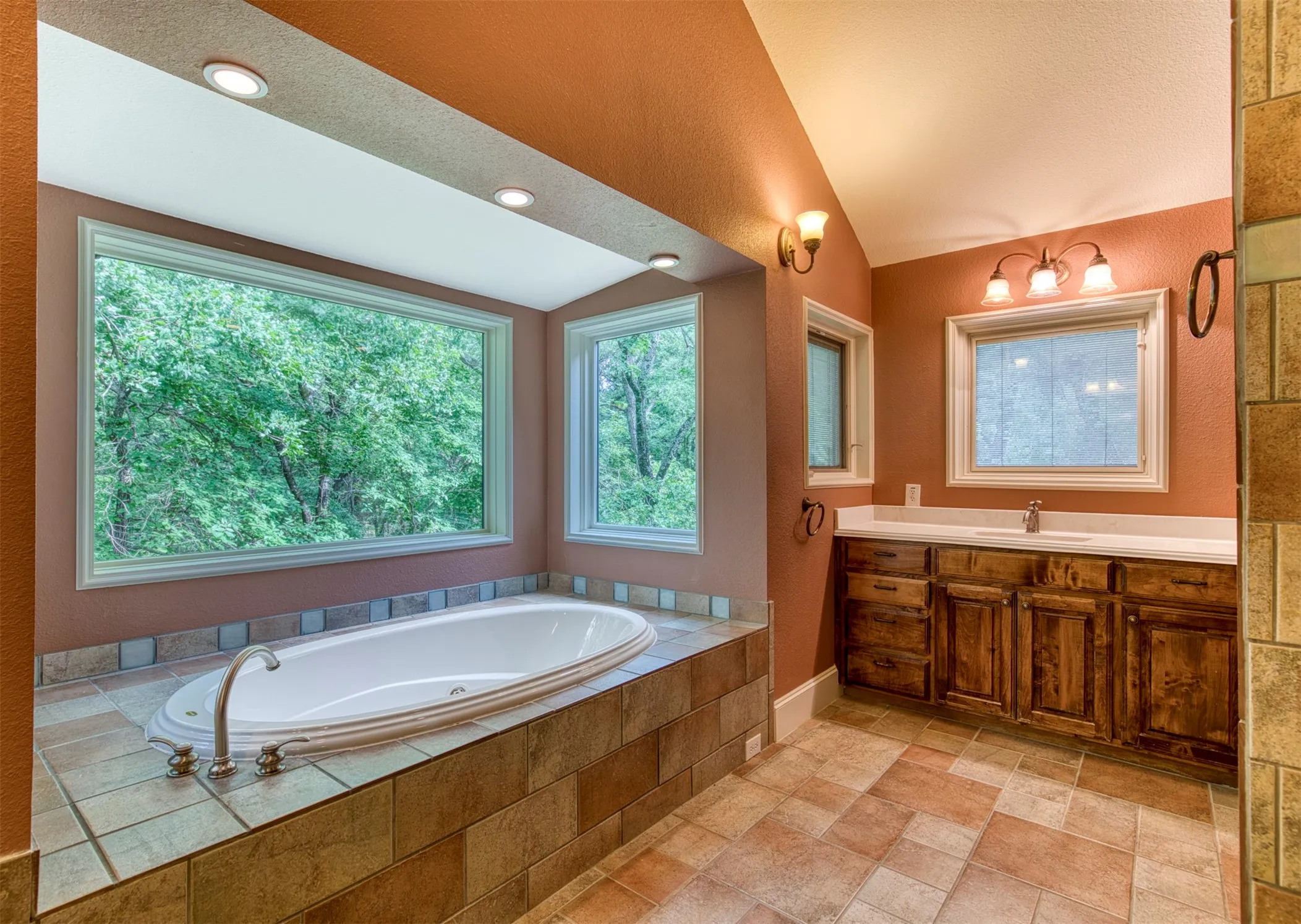 En-suite bath with soaking tub with views and dual vanities.