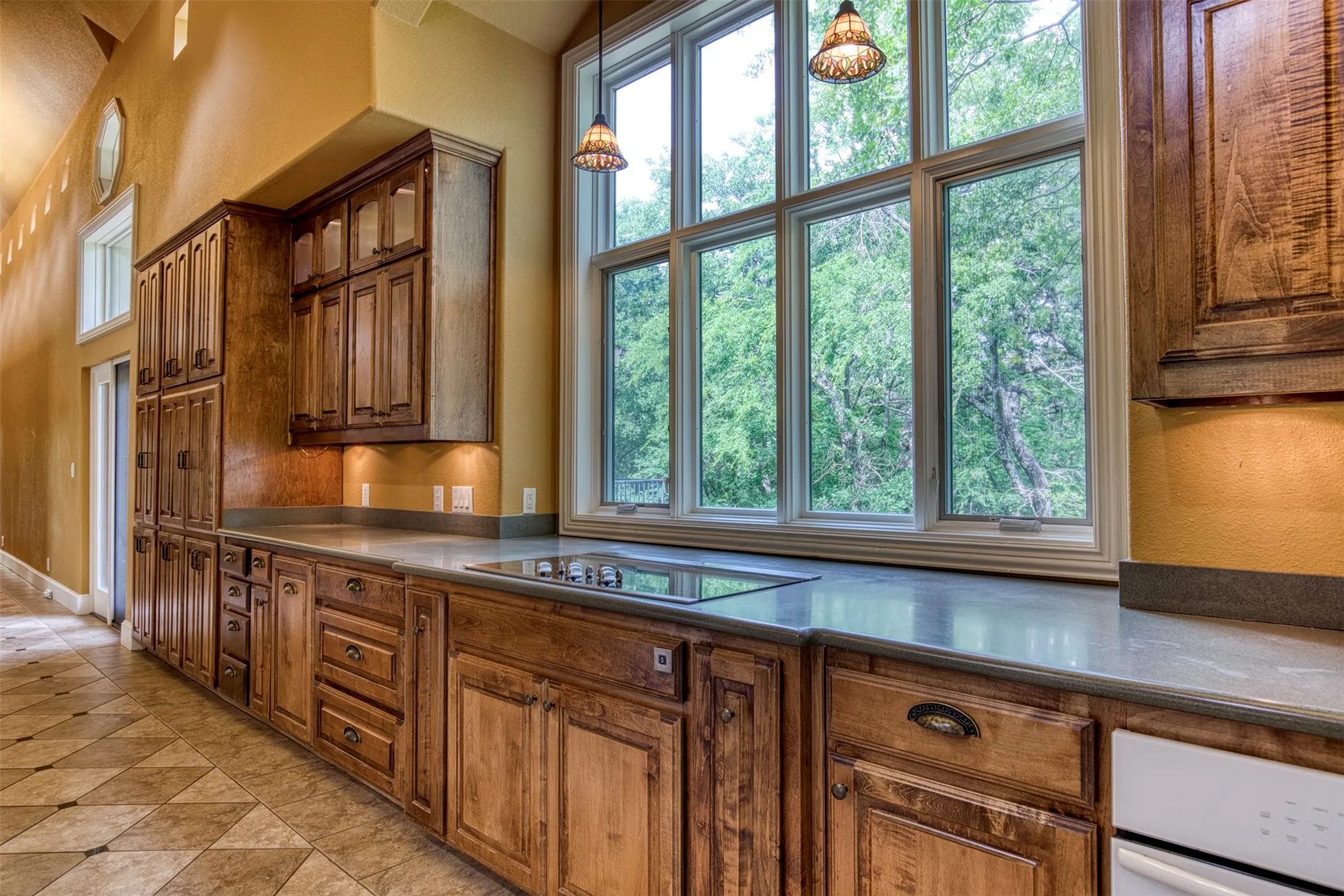 Kitchen with an abundance of cabinetry and serene views of back of estate and courtyard.