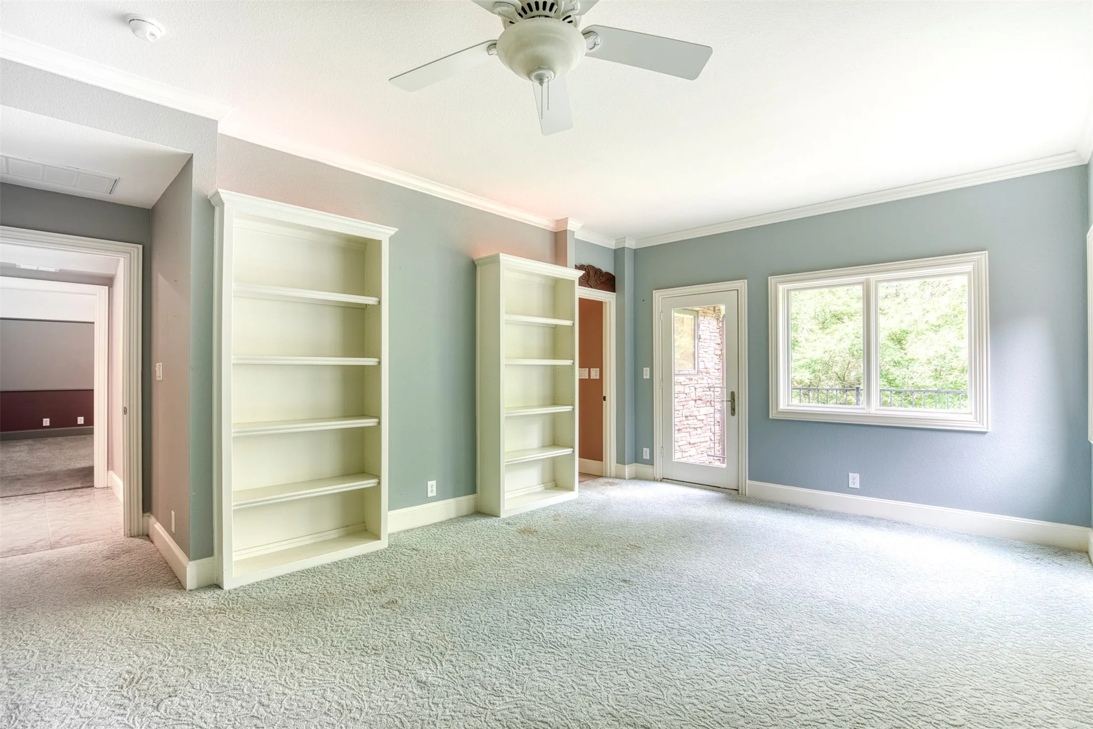 Upstairs bedroom with built-ins and balcony.