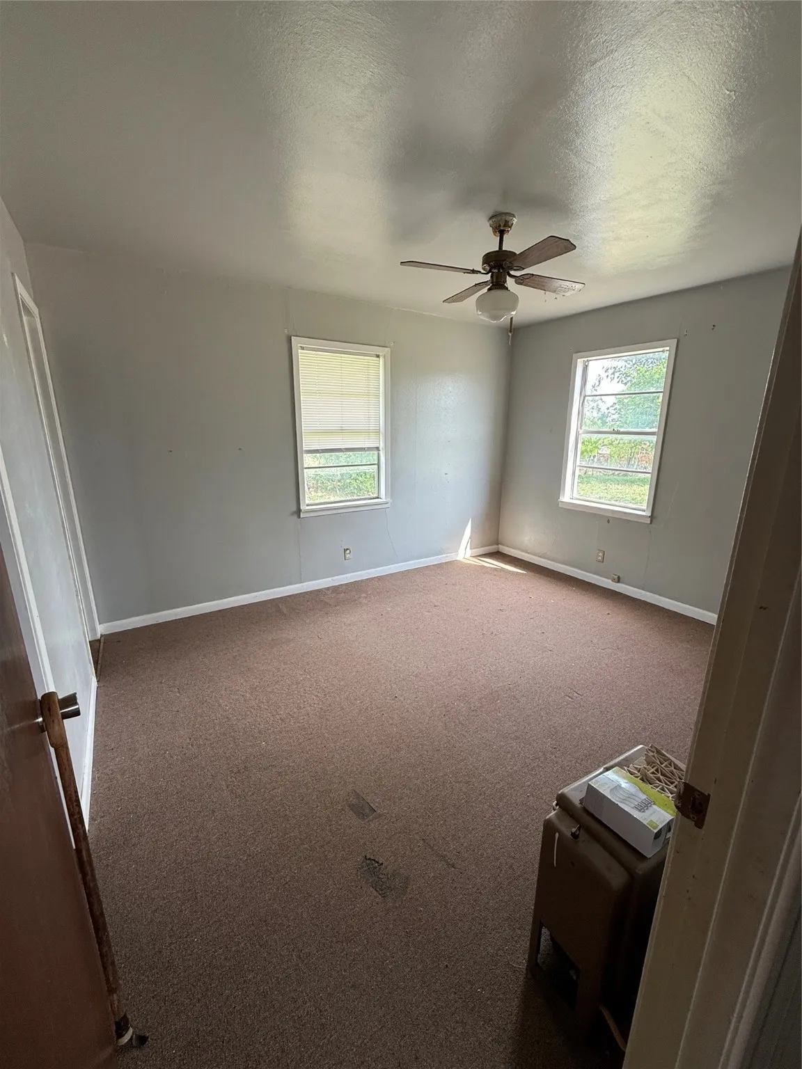 Carpeted spare room with baseboards, ceiling fan, and a textured ceiling