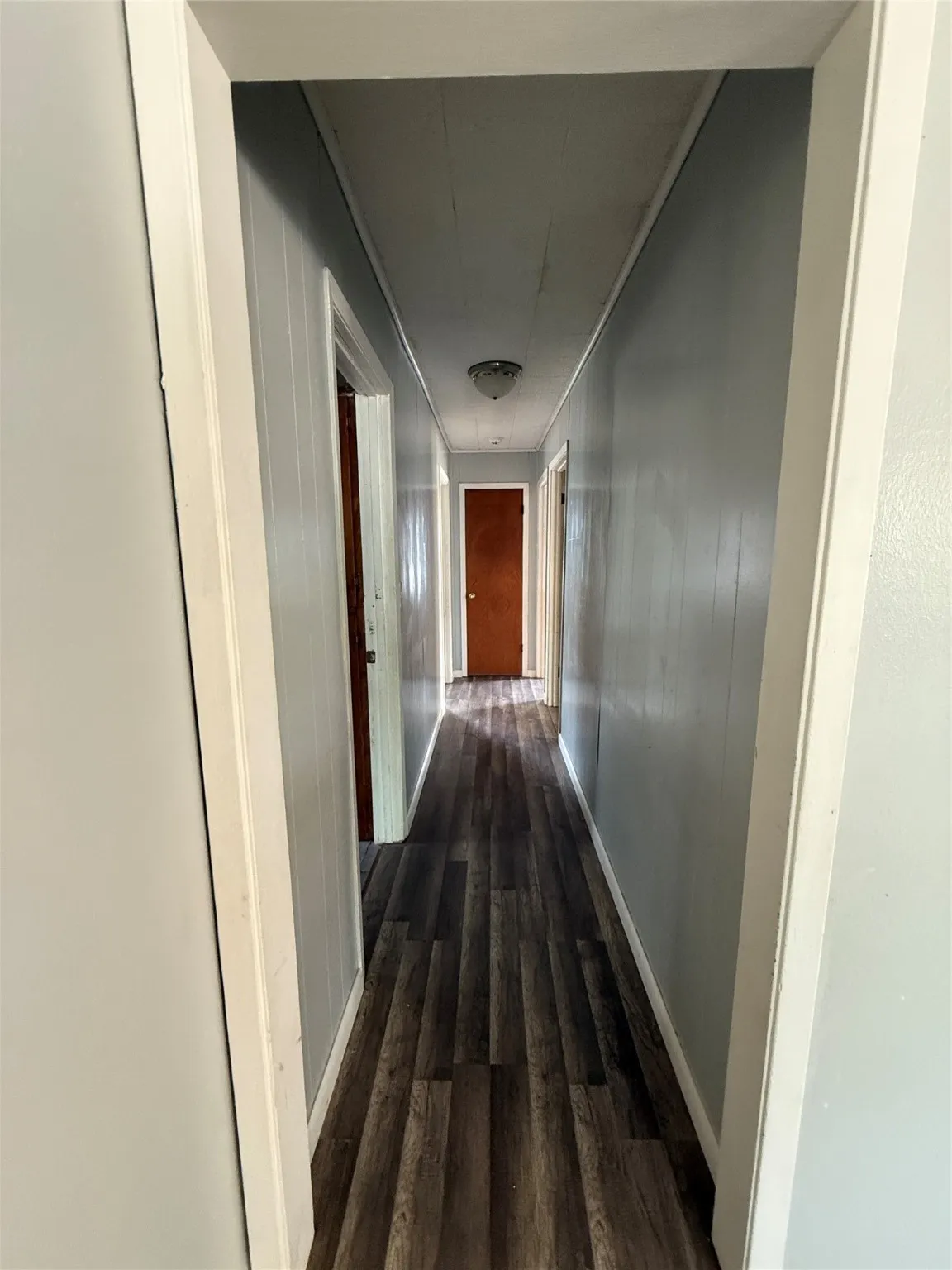 Corridor featuring dark wood-style flooring