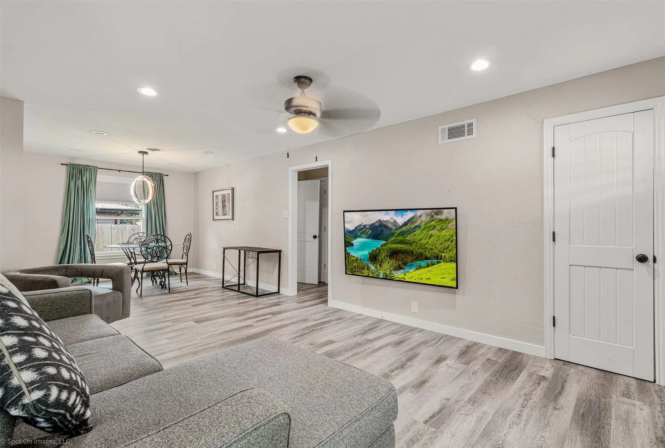 Living room featuring wood finished floors, baseboards, recessed lighting, and ceiling fan
