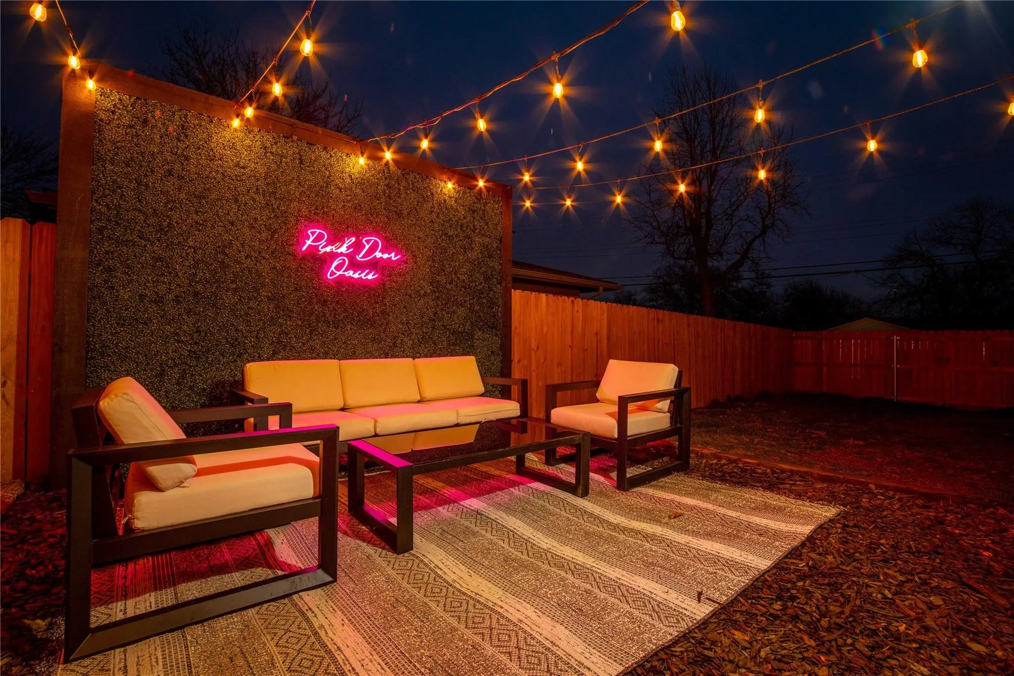 Patio at night with an outdoor living space and a fenced backyard