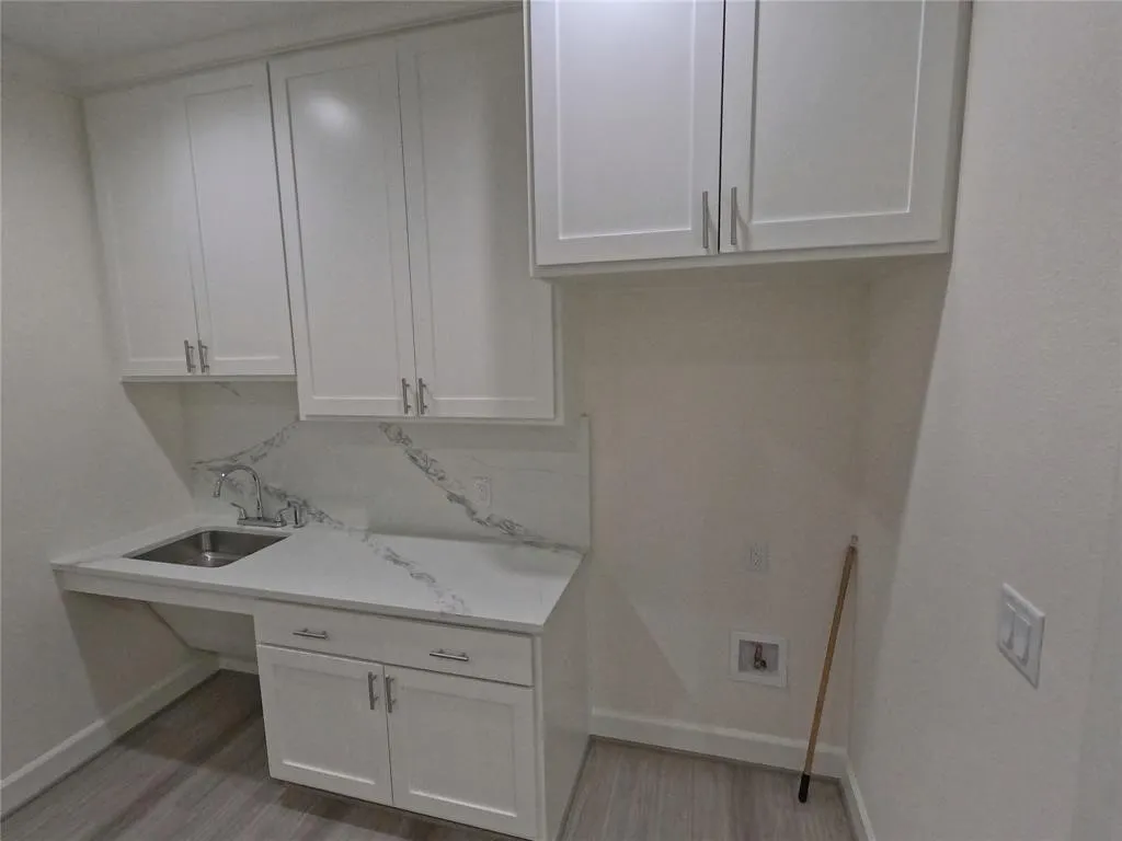 Laundry area featuring baseboards, light wood finished floors, cabinet space, and washer​​‌​​​​‌​​‌‌​‌‌​​​‌‌​‌​‌​‌​​​‌​​ hookup