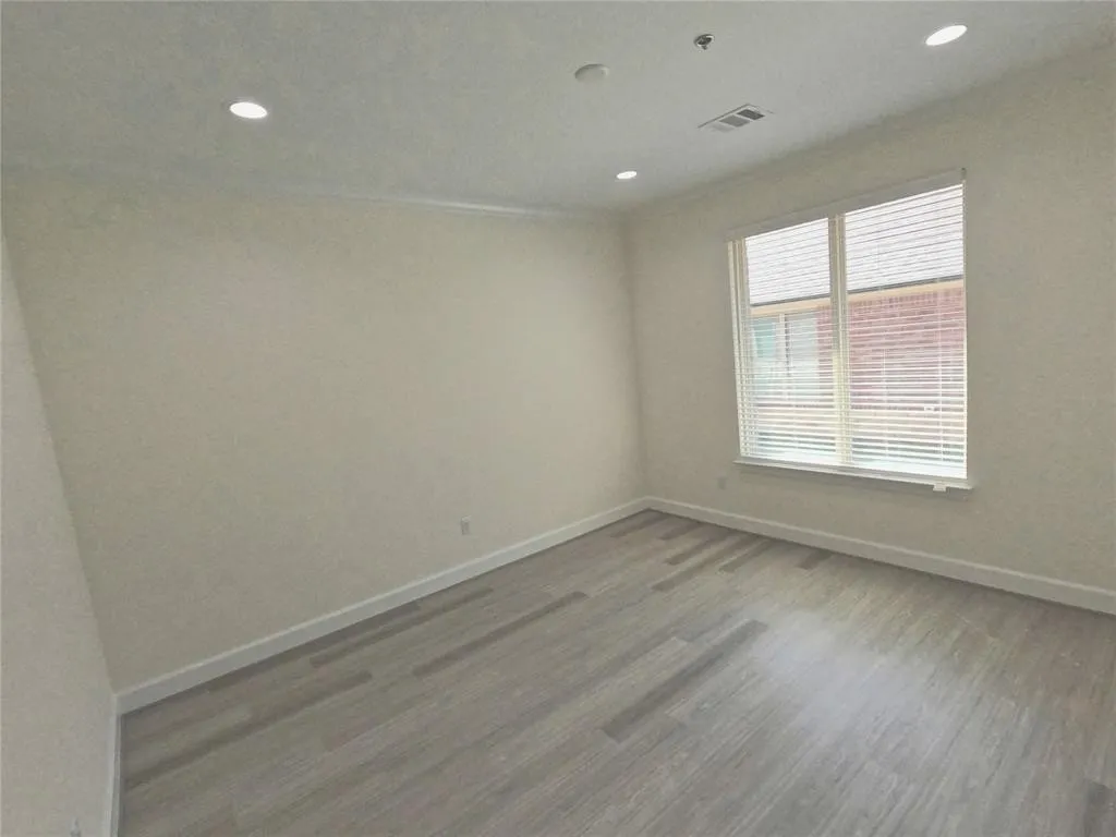 Unfurnished room featuring baseboards, wood finished floors, and recessed lighting
