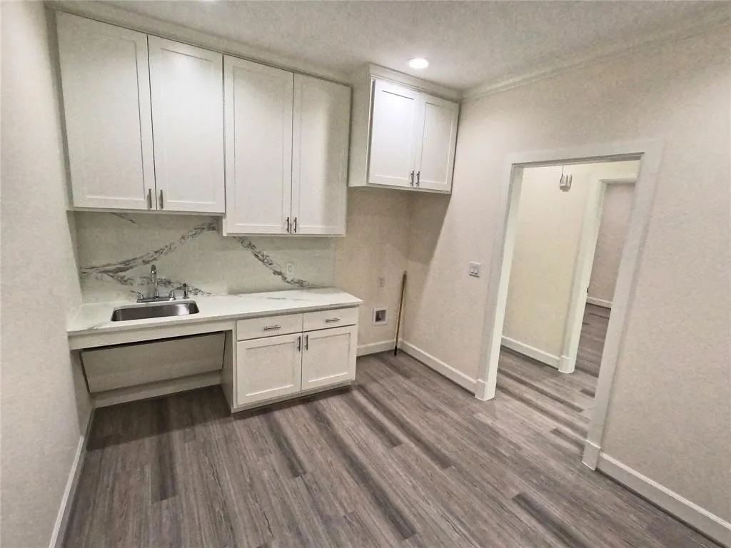 Laundry area with cabinet space, baseboards, dark wood finished floors, a textured ceiling, and recessed lighting