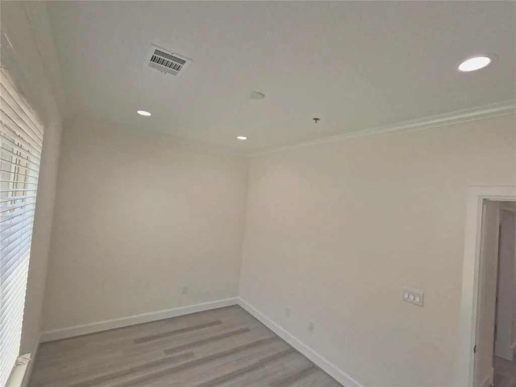 Unfurnished room with ornamental molding, light wood-type flooring, baseboards, and recessed lighting
