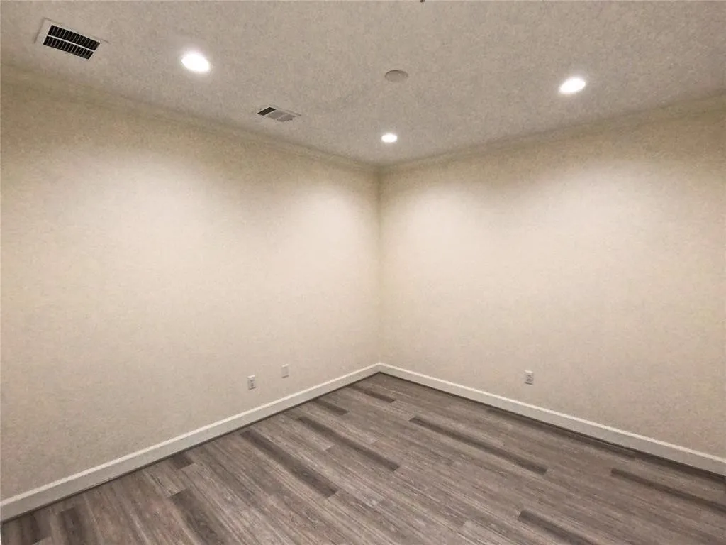 Empty room with recessed lighting, dark wood-type flooring, and baseboards