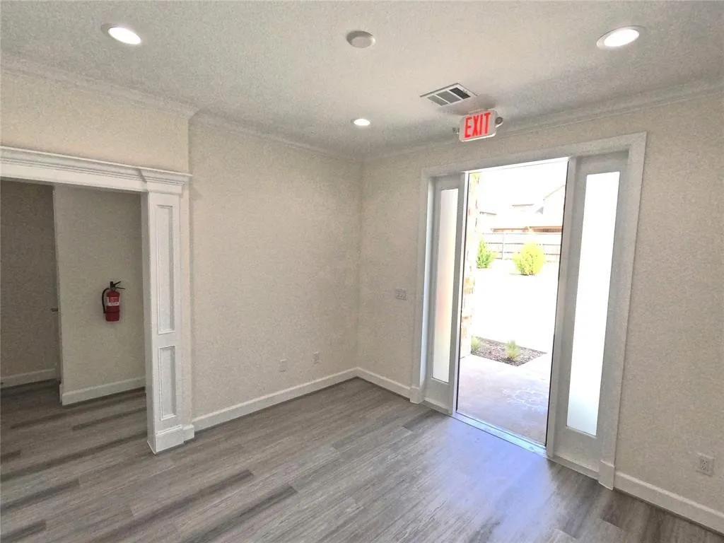 Entryway with ornamental molding, wood finished floors, recessed lighting, and baseboards