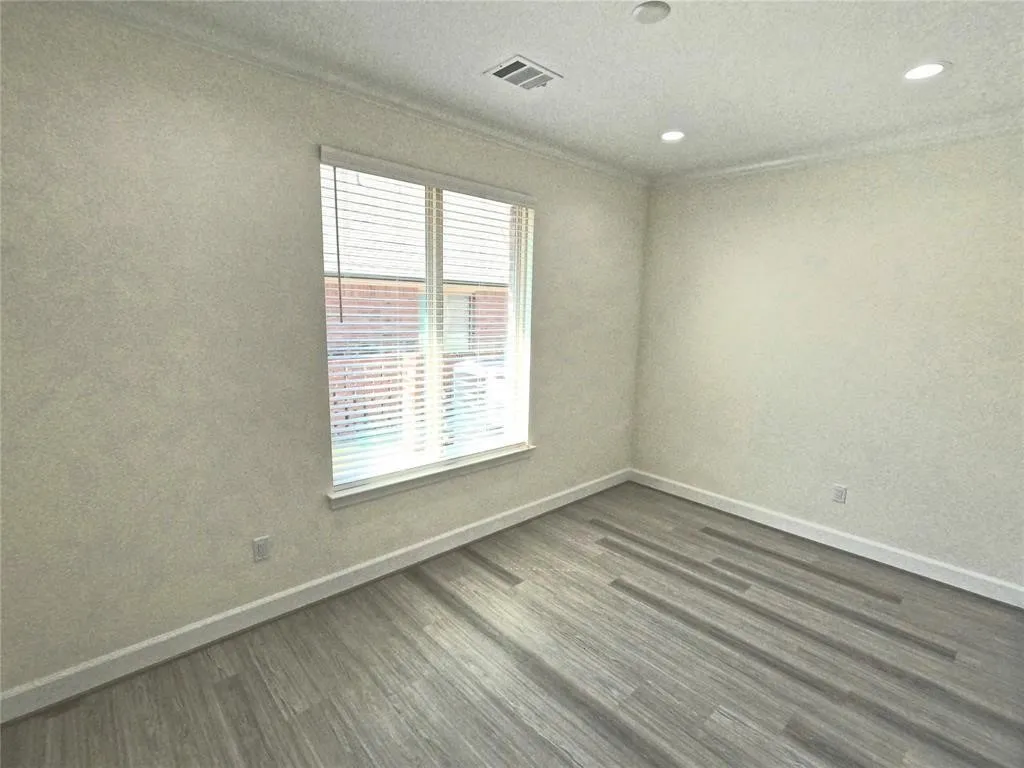 Unfurnished room featuring baseboards, dark wood-type flooring, crown molding, and recessed lighting