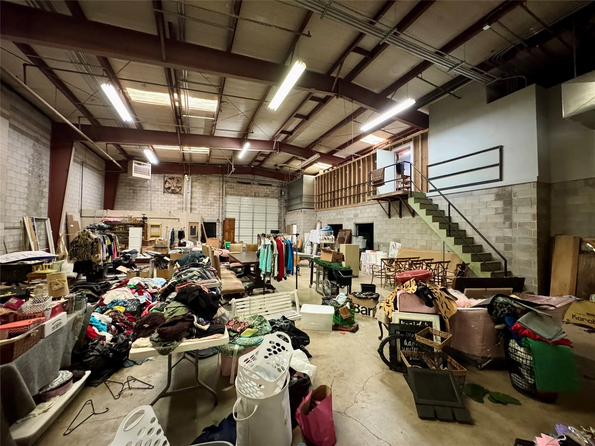 Miscellaneous room with concrete floors, stairs, and brick wall