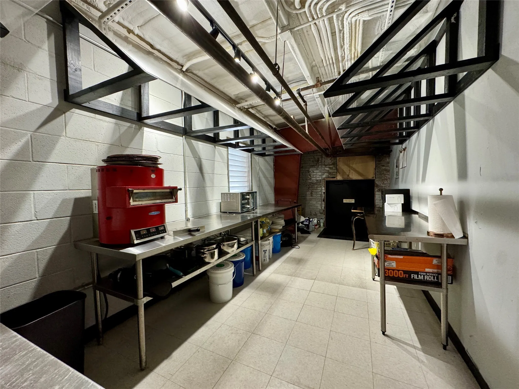Unfinished basement featuring tile patterned floors and concrete block wall