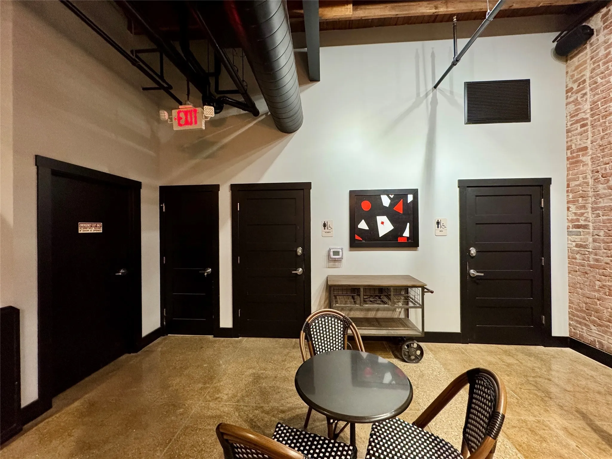 Foyer with a high ceiling, brick wall, and baseboards