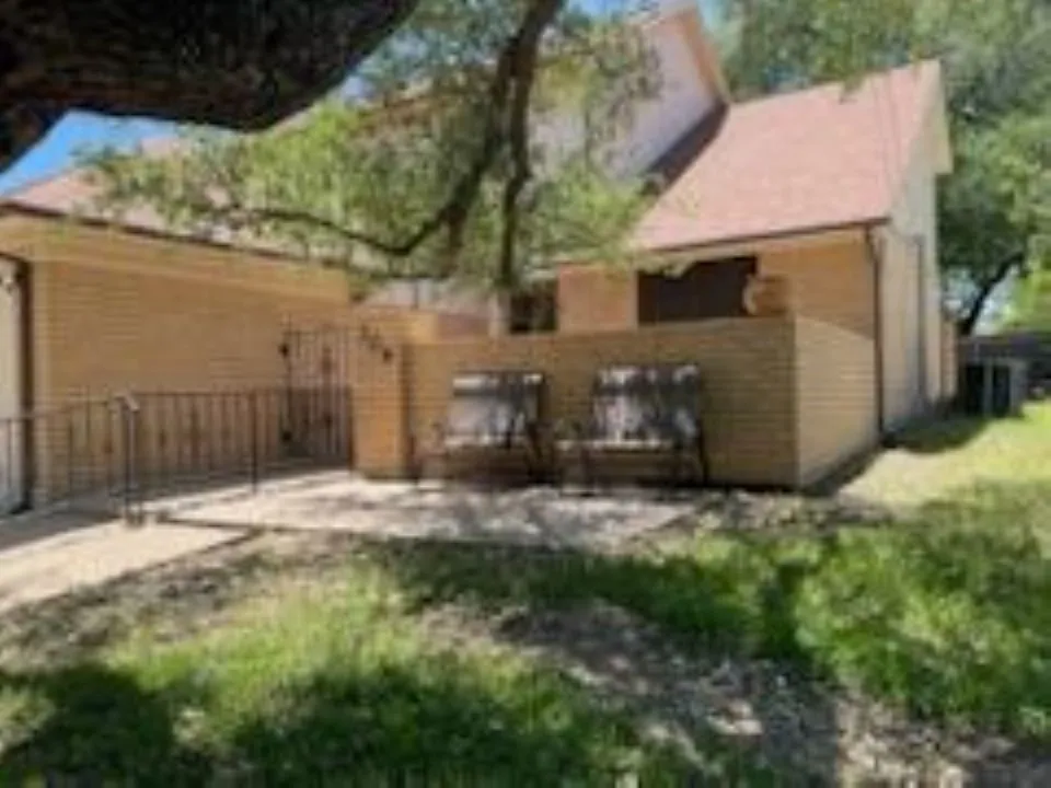 Back of property featuring fence and a patio