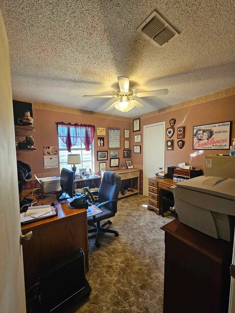 Home office with ceiling fan, a textured ceiling, and carpet flooring