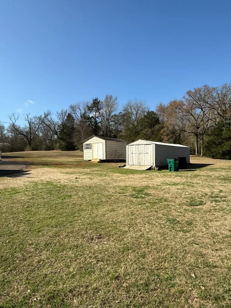 View of grassy yard with a storage shed and an outdoor structure