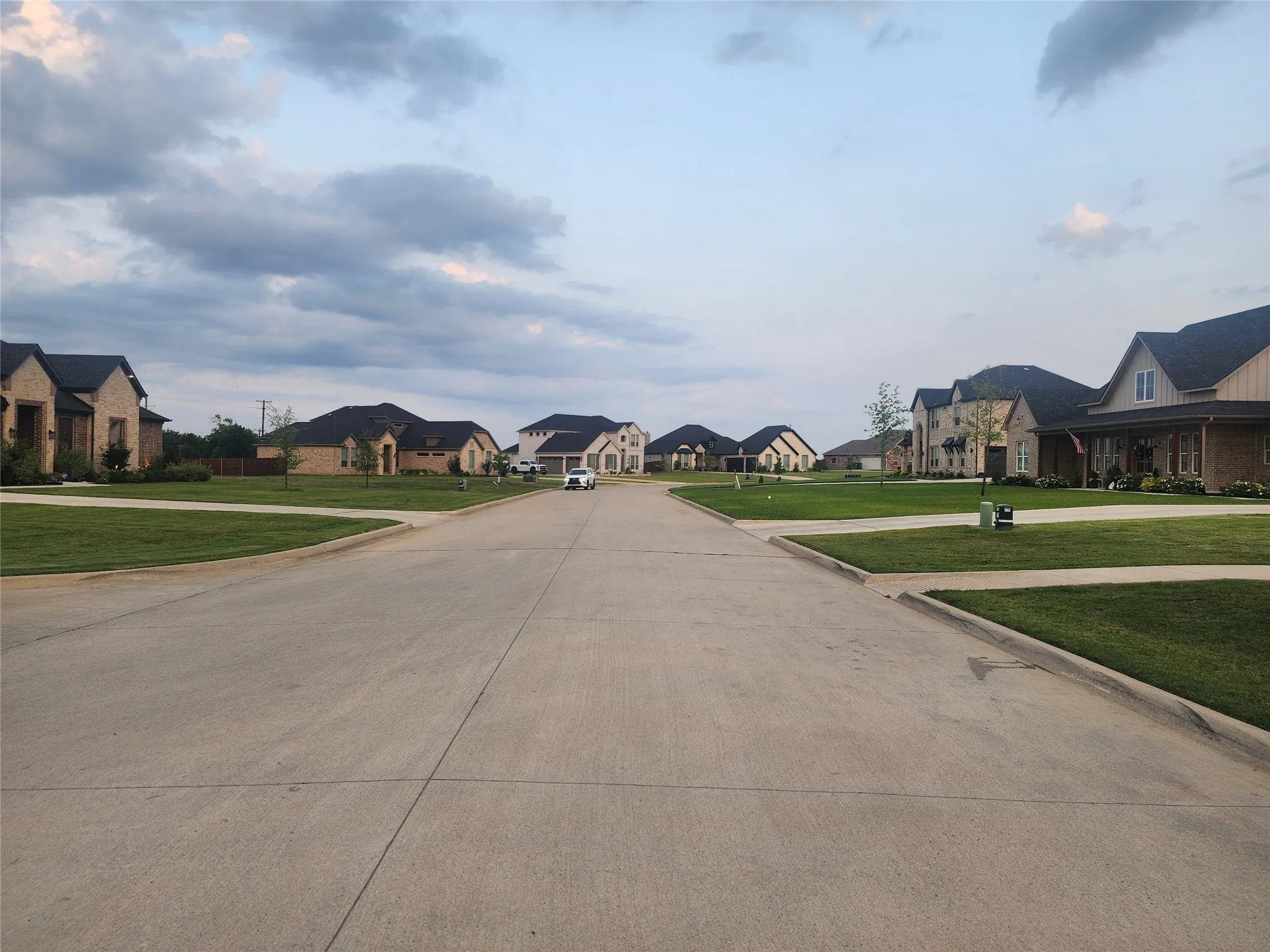 View of concrete road with a residential view and curbs