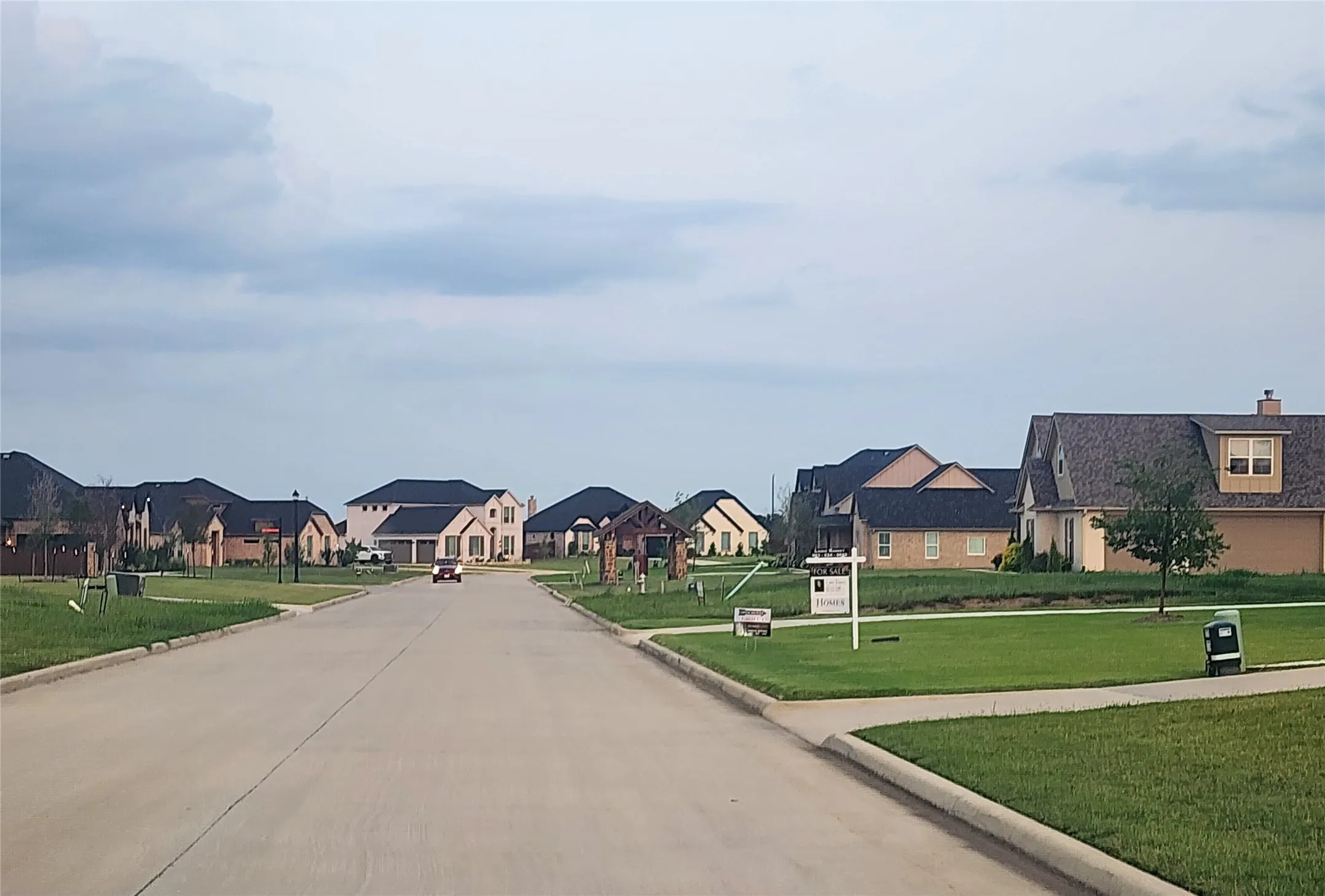 View of concrete road with a residential view and curbs