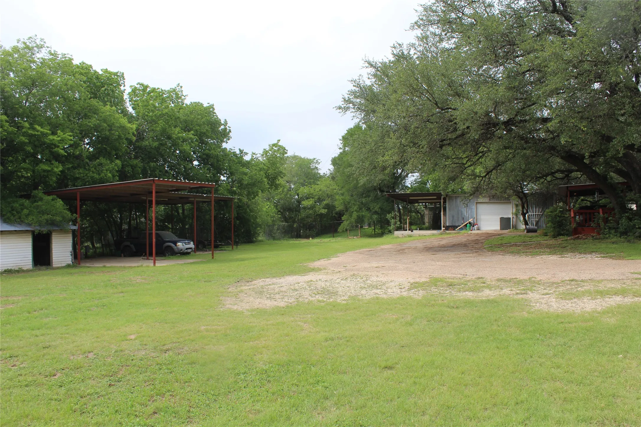 Expansive grassy yard area with multiple detached structures