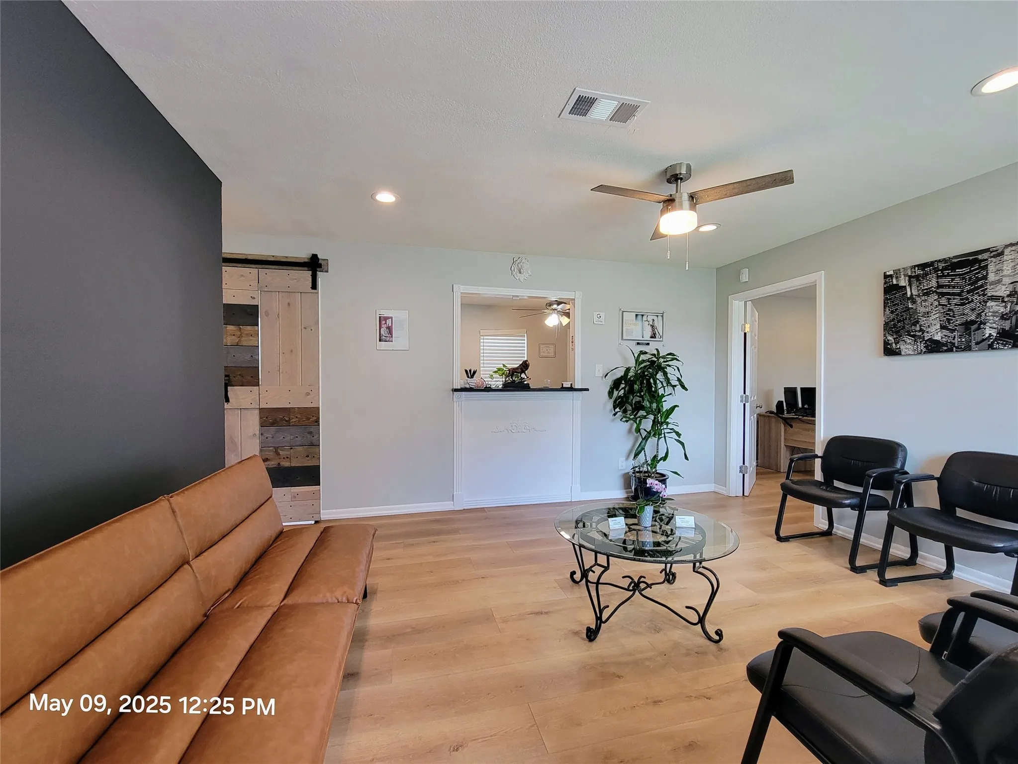 Living room featuring a barn door, light wood finished floors, a ceiling fan, recessed lighting, and baseboards