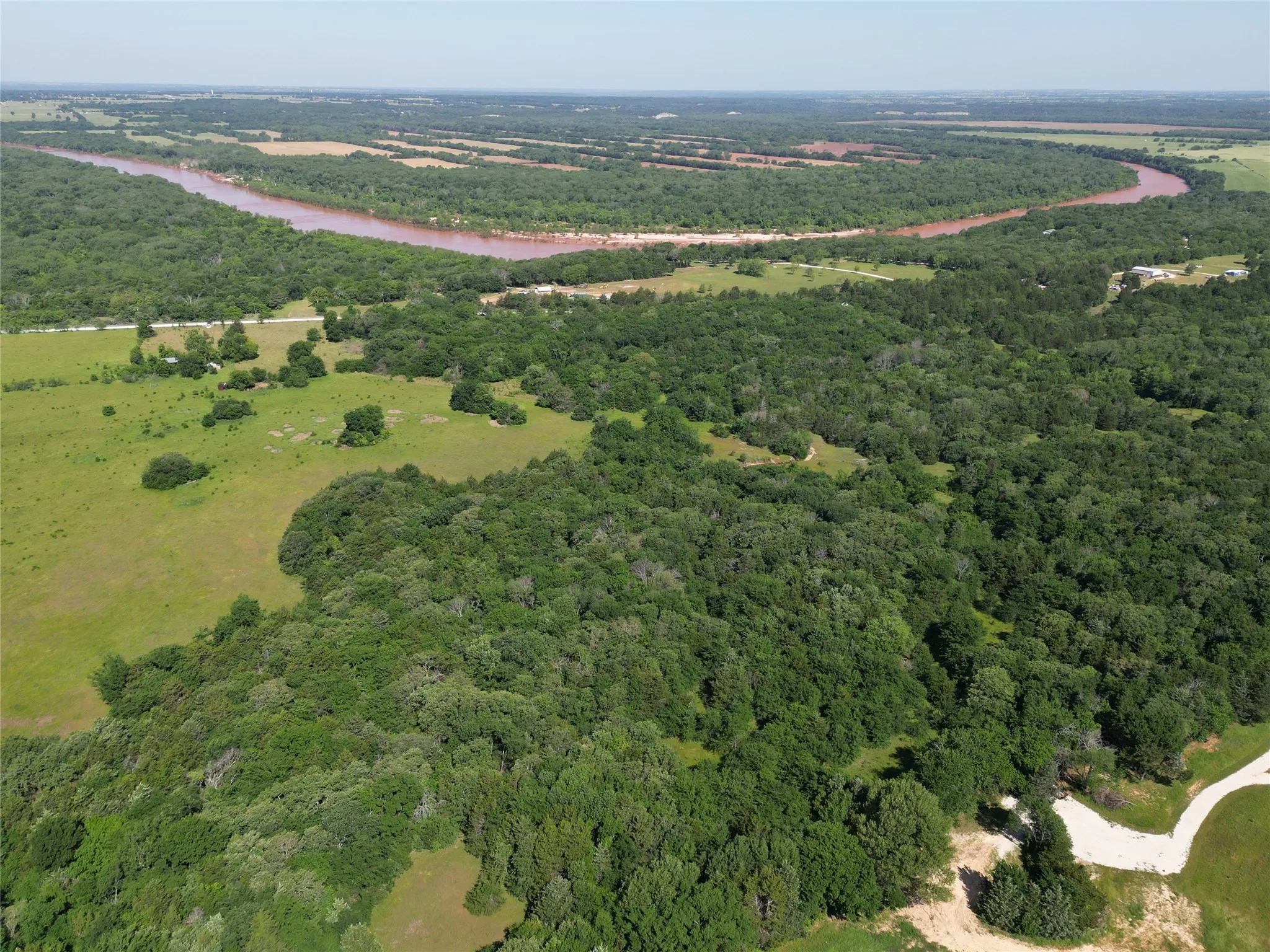 View from southeast side, showing proximity to the Red River bordering northwest of property
