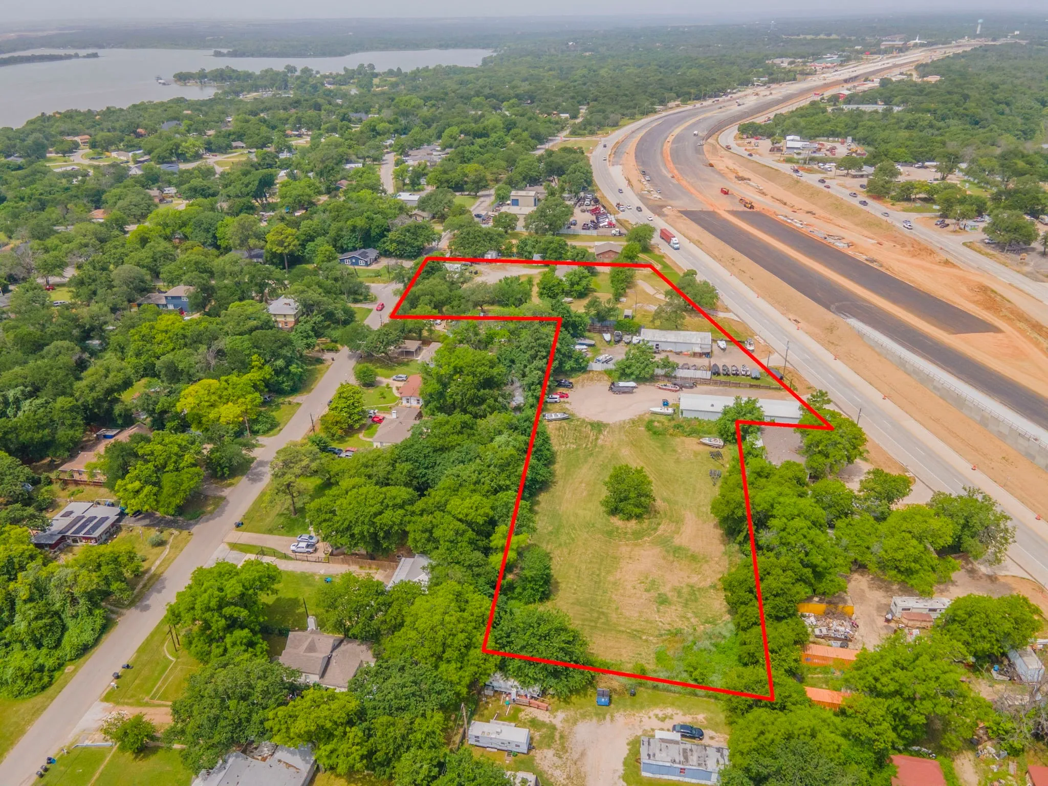 View of property location with a large body of water, property boundaries highlighted, and a highway
