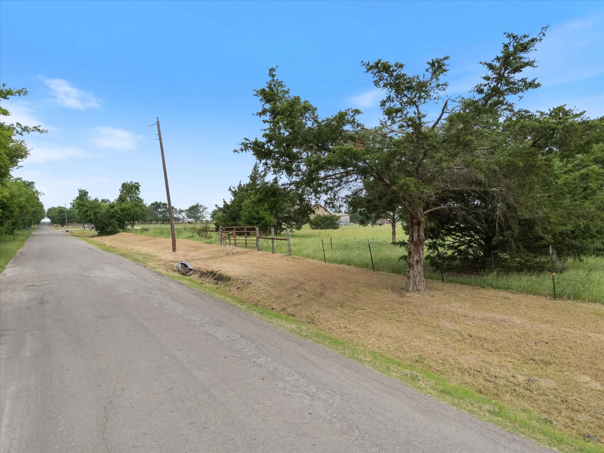 View of asphalt street featuring a view of rural / pastoral area