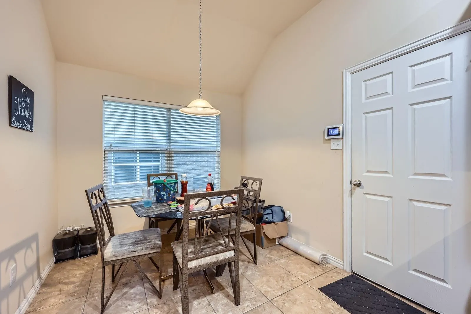 Dining area featuring vaulted ceiling, baseboards, and light tile patterned floors