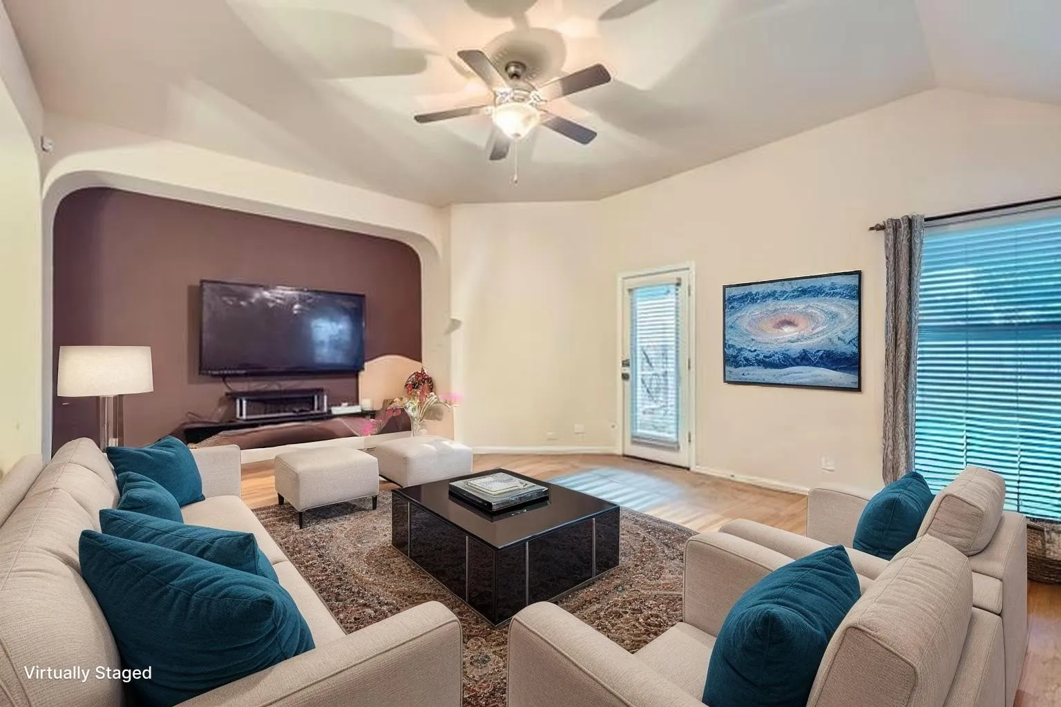 Living room featuring wood finished floors, baseboards, ceiling fan, and lofted ceiling