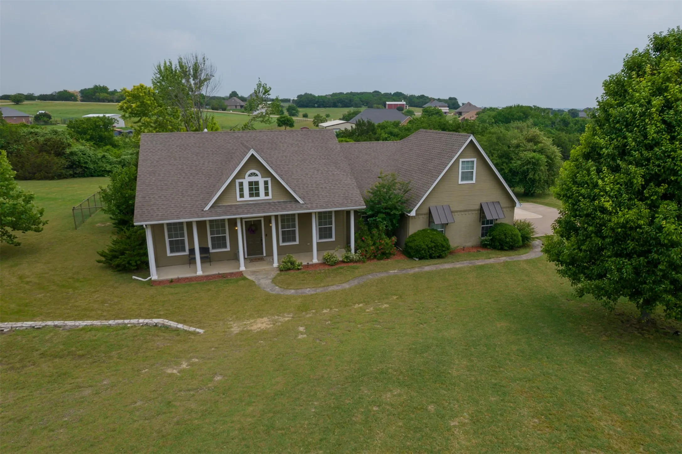 View of front facade with covered porch and a front lawn