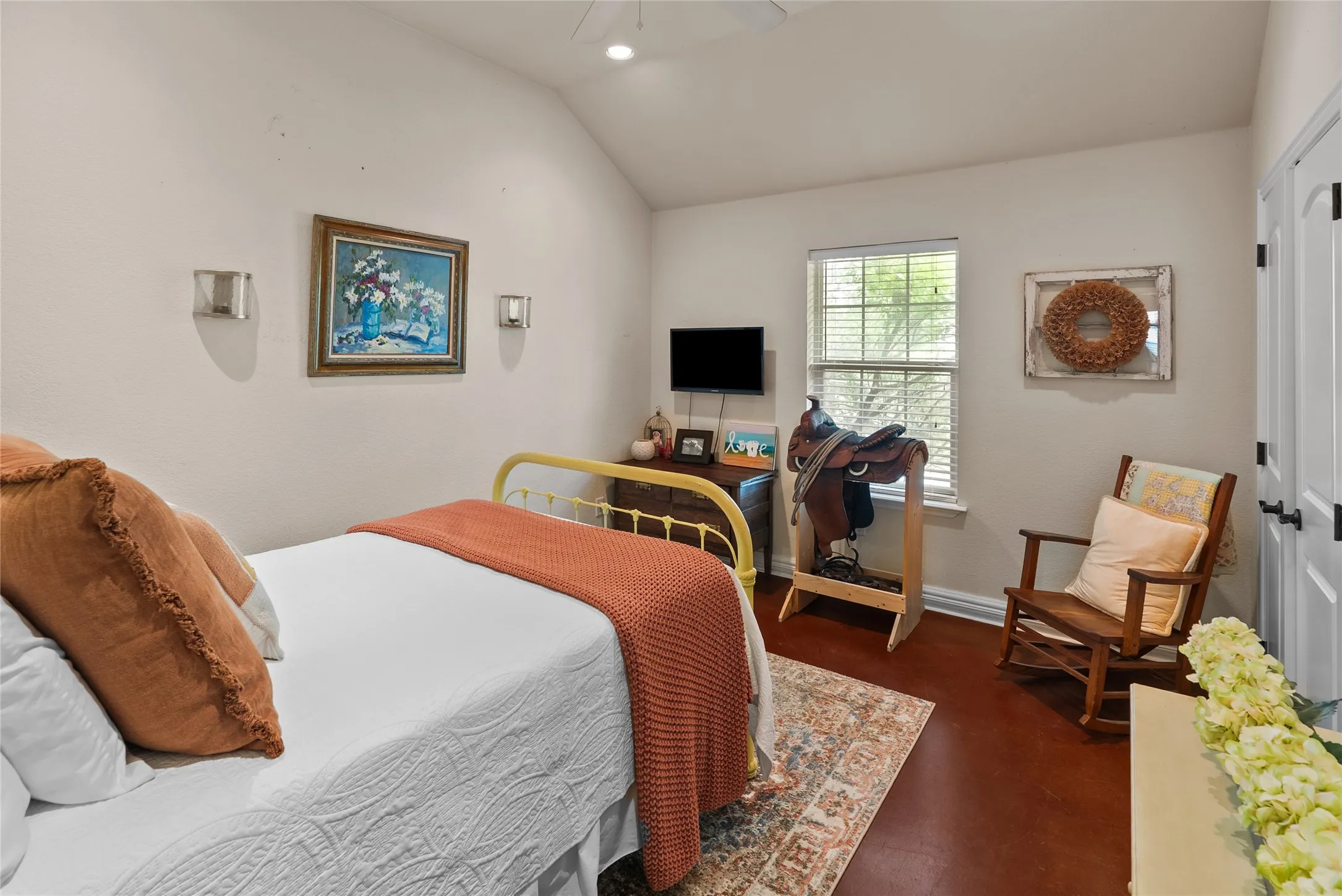 Bedroom with lofted ceiling, baseboards, and finished concrete floors
