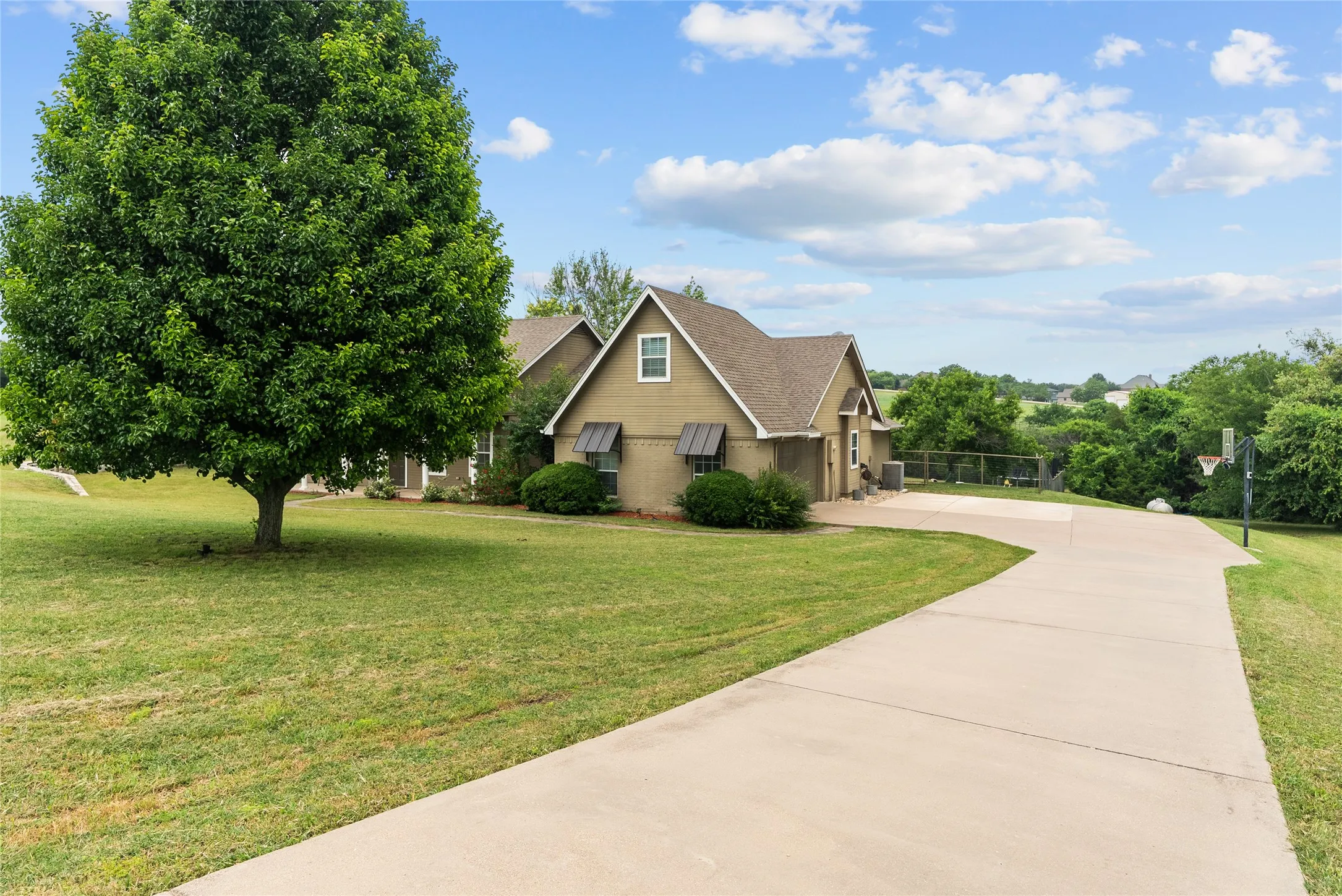 View of front of property featuring concrete driveway, a front yard, and a shingled roof