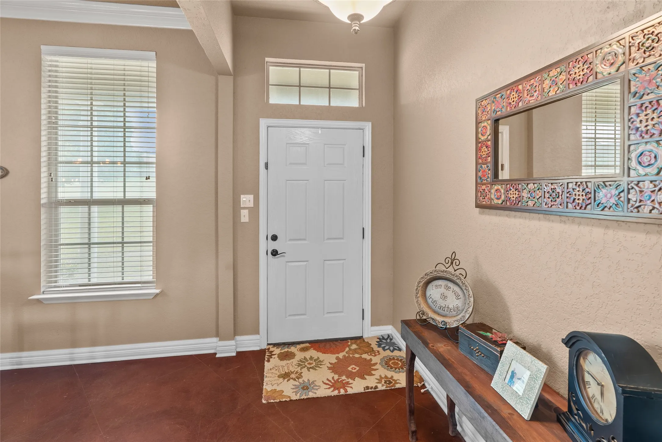 Entrance foyer featuring dark tile patterned flooring, healthy amount of natural light, and baseboards