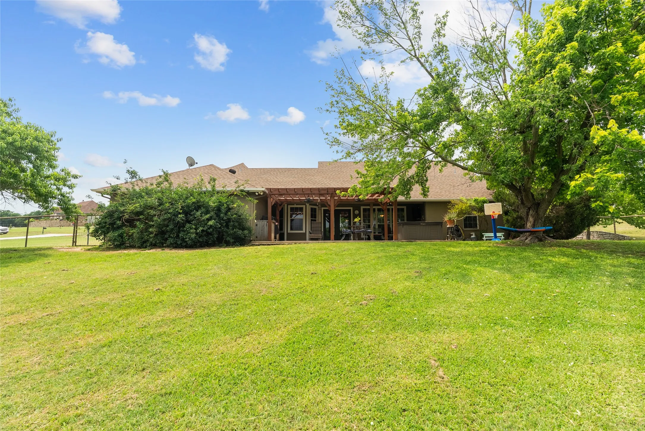 Rear view of property featuring roof with shingles and a pergola