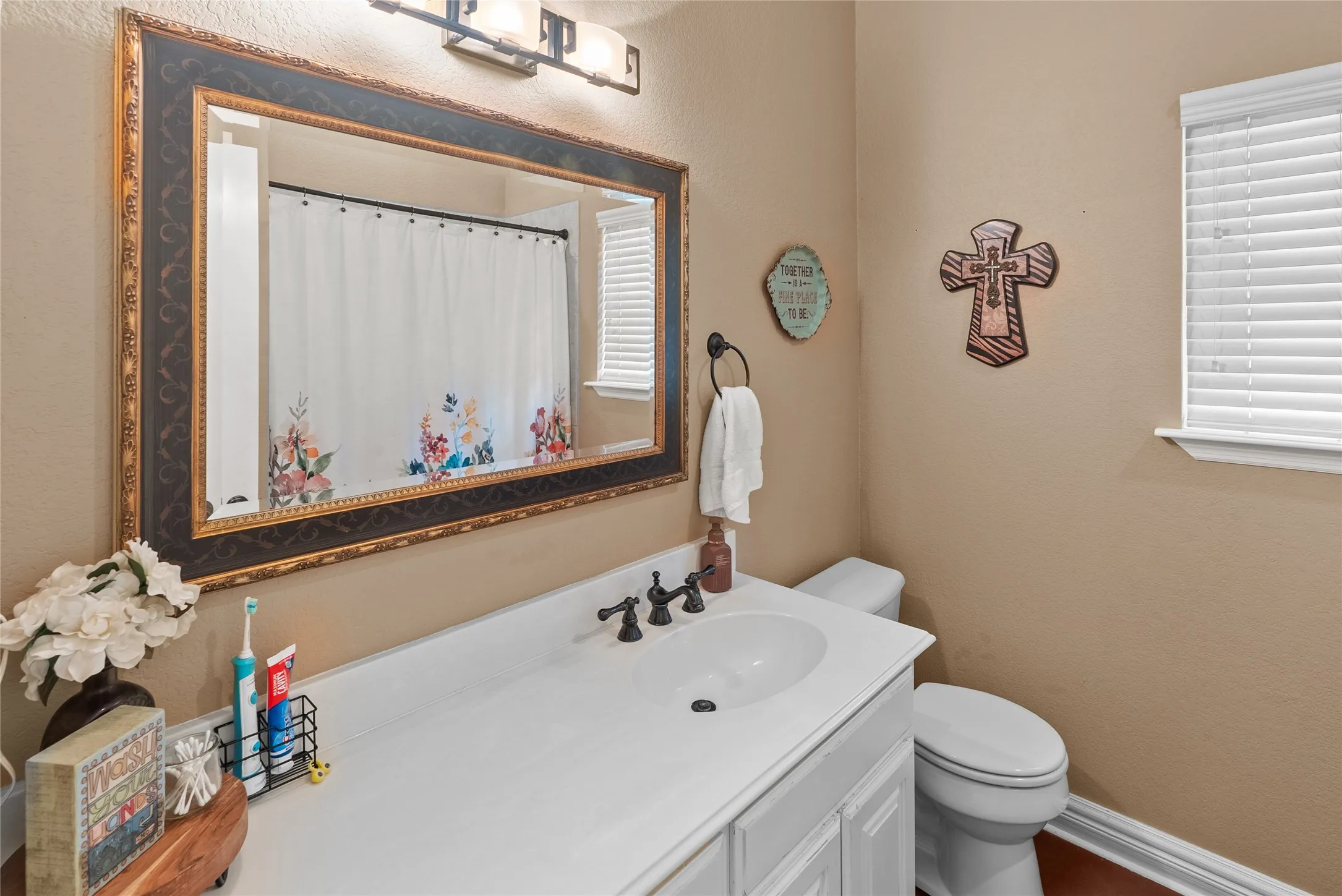 Bathroom with toilet, vanity, and a shower with curtain