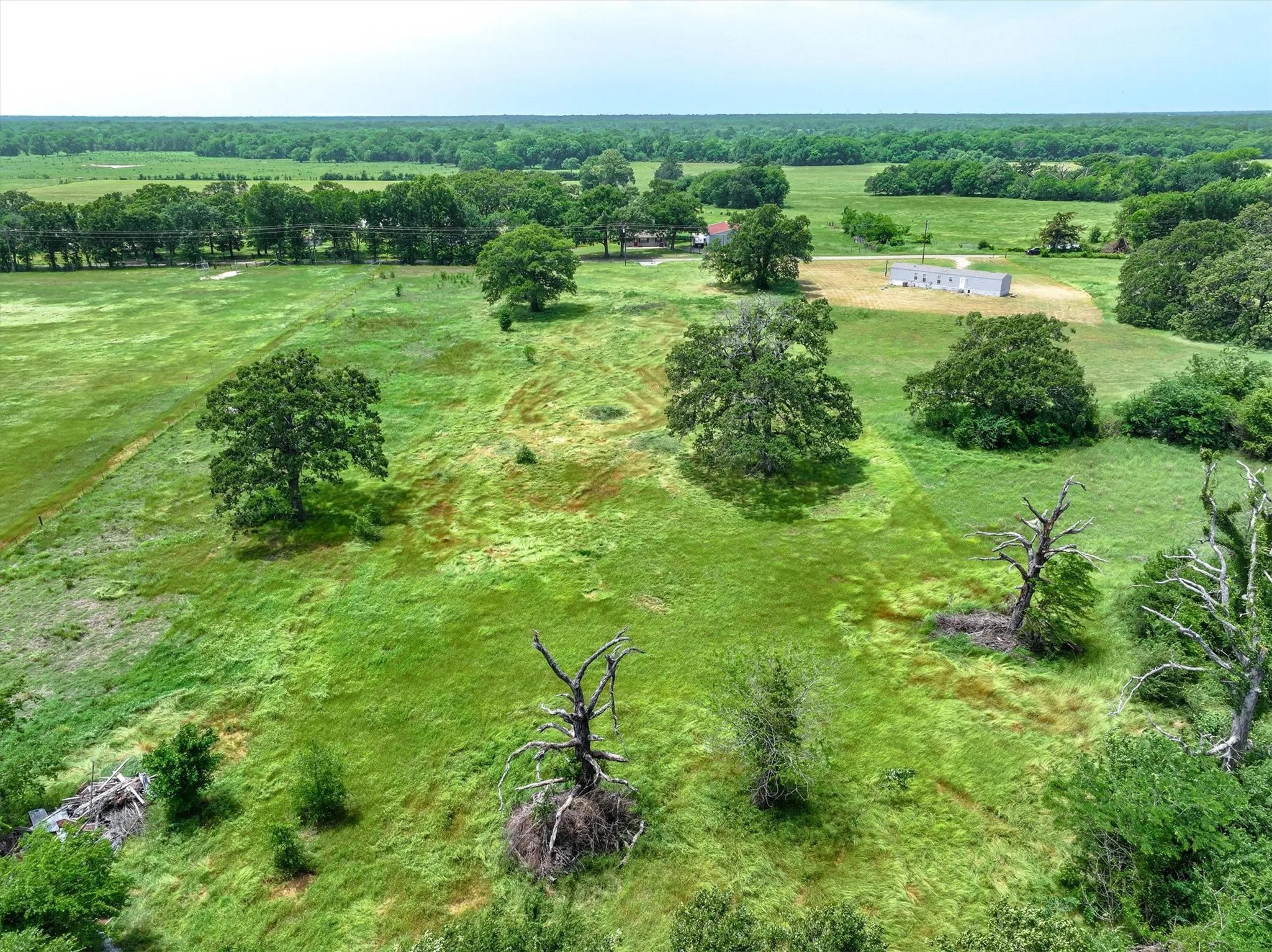 Aerial view of back side of property and surrounding area featuring rural landscape