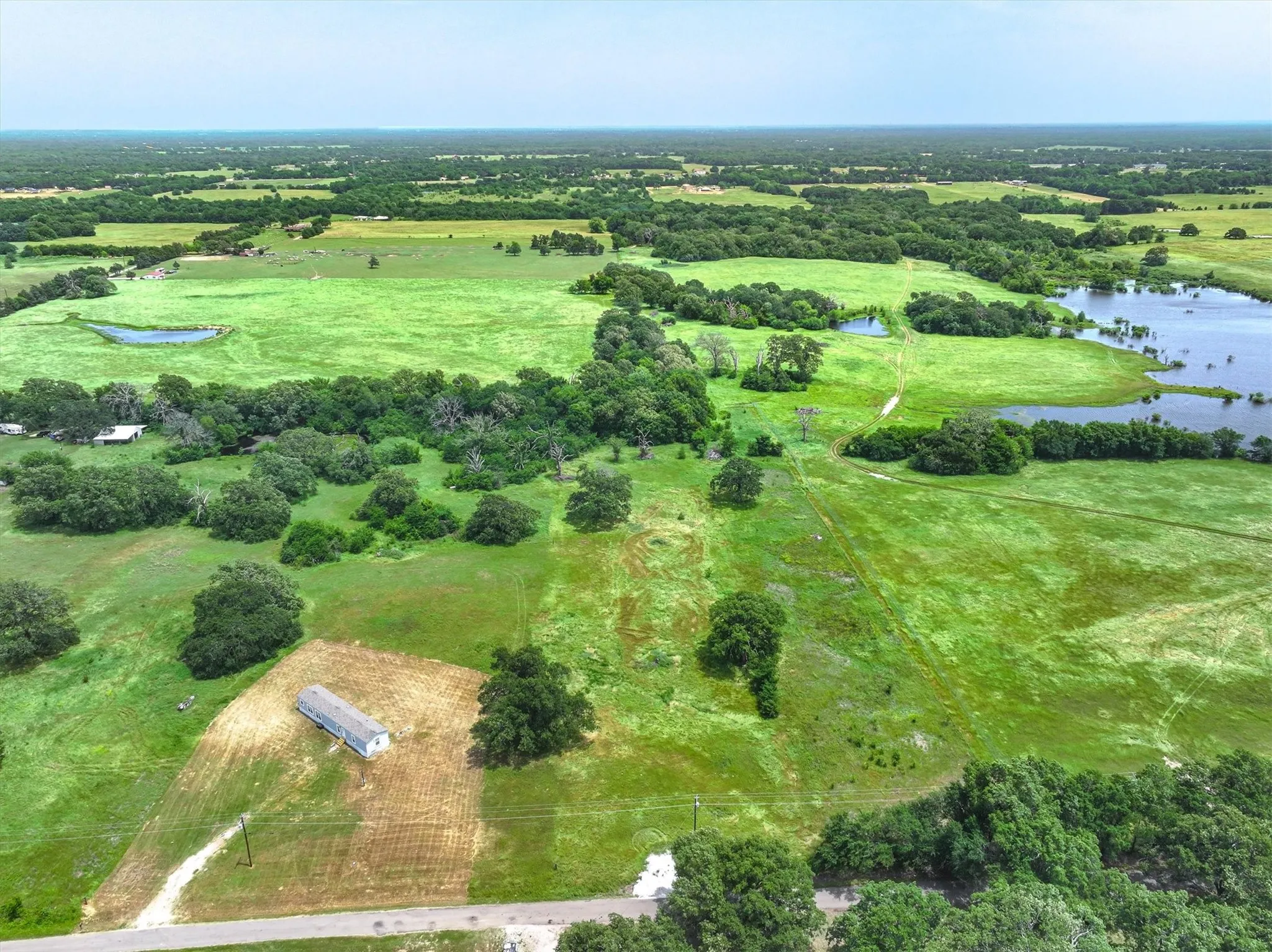 Aerial view of property's location featuring a nearby body of water and rural landscape
