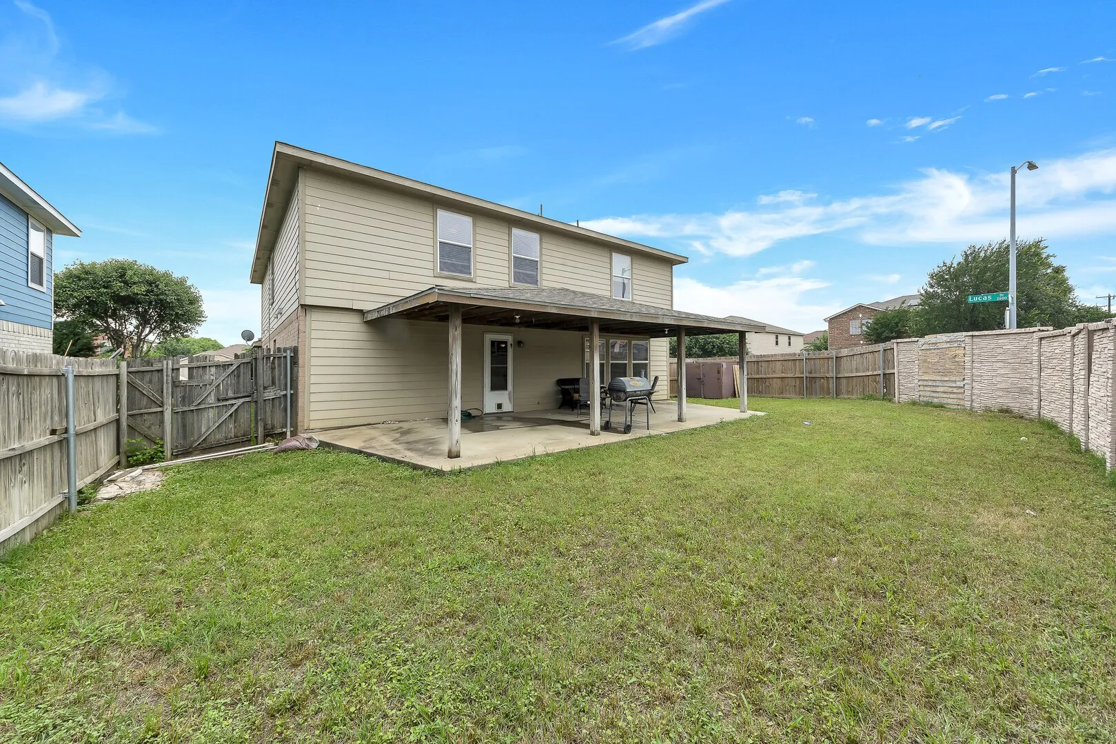 Rear view of property featuring a patio and a gate