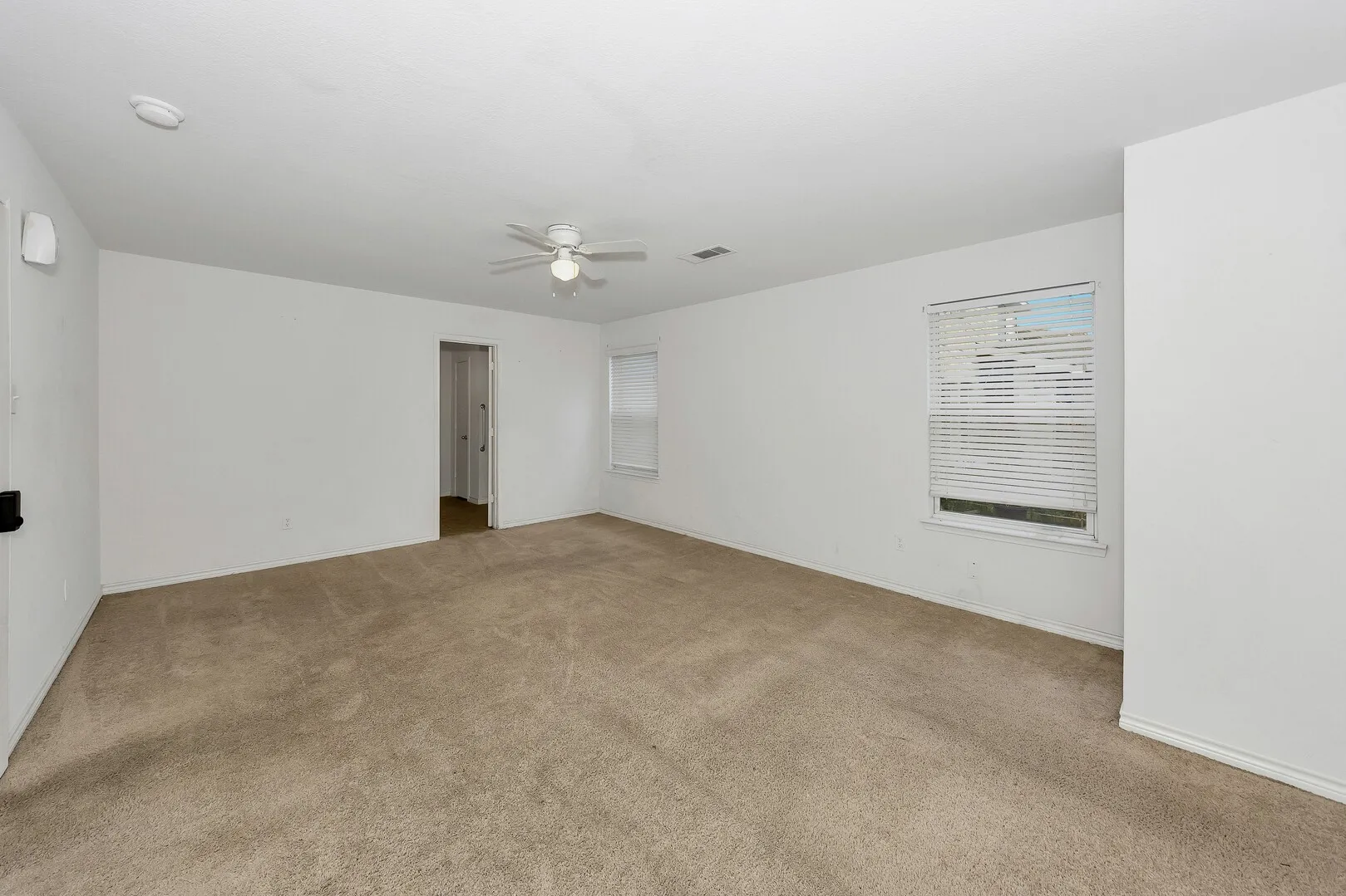 Unfurnished room featuring carpet, a ceiling fan, a smoke detector, and baseboards