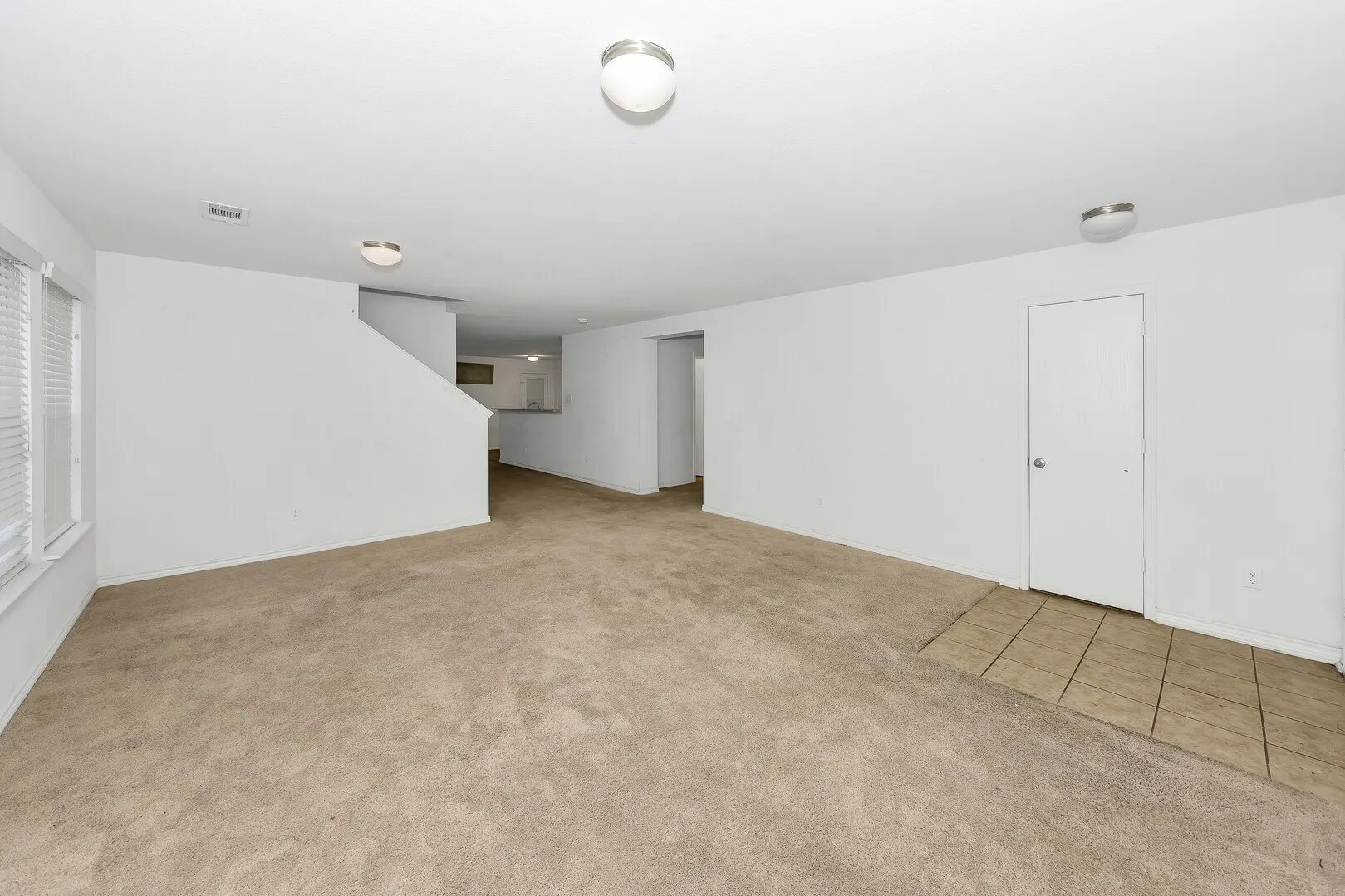 Empty room featuring carpet floors and stairway