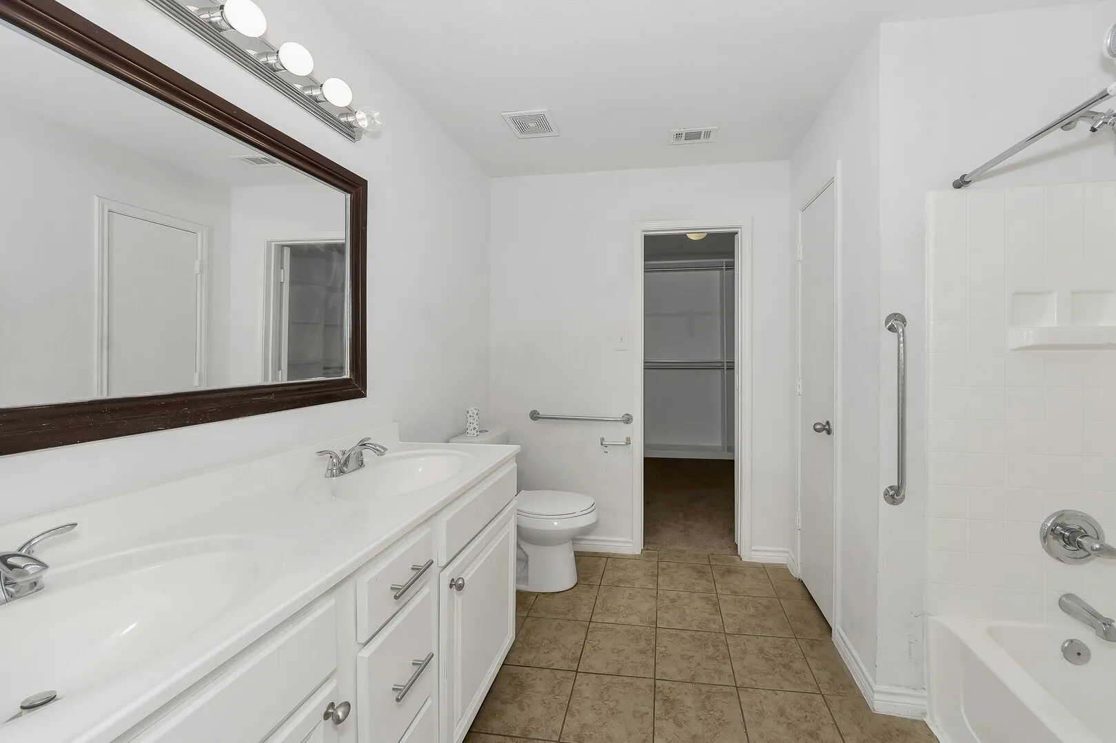 Full bathroom with tile patterned flooring, toilet, tub / shower combination, and double vanity